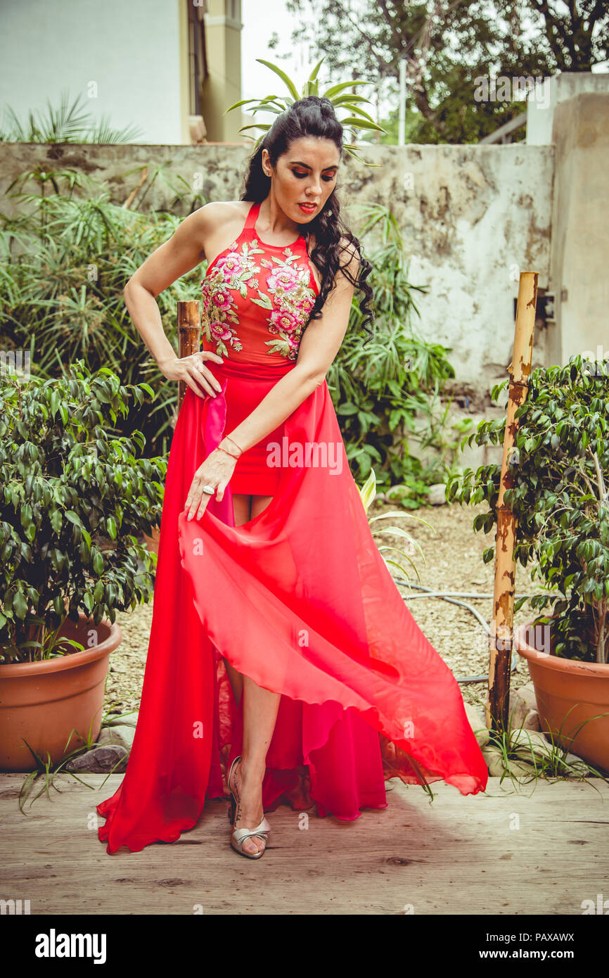 Girl with red dress in garden Banque D'Images