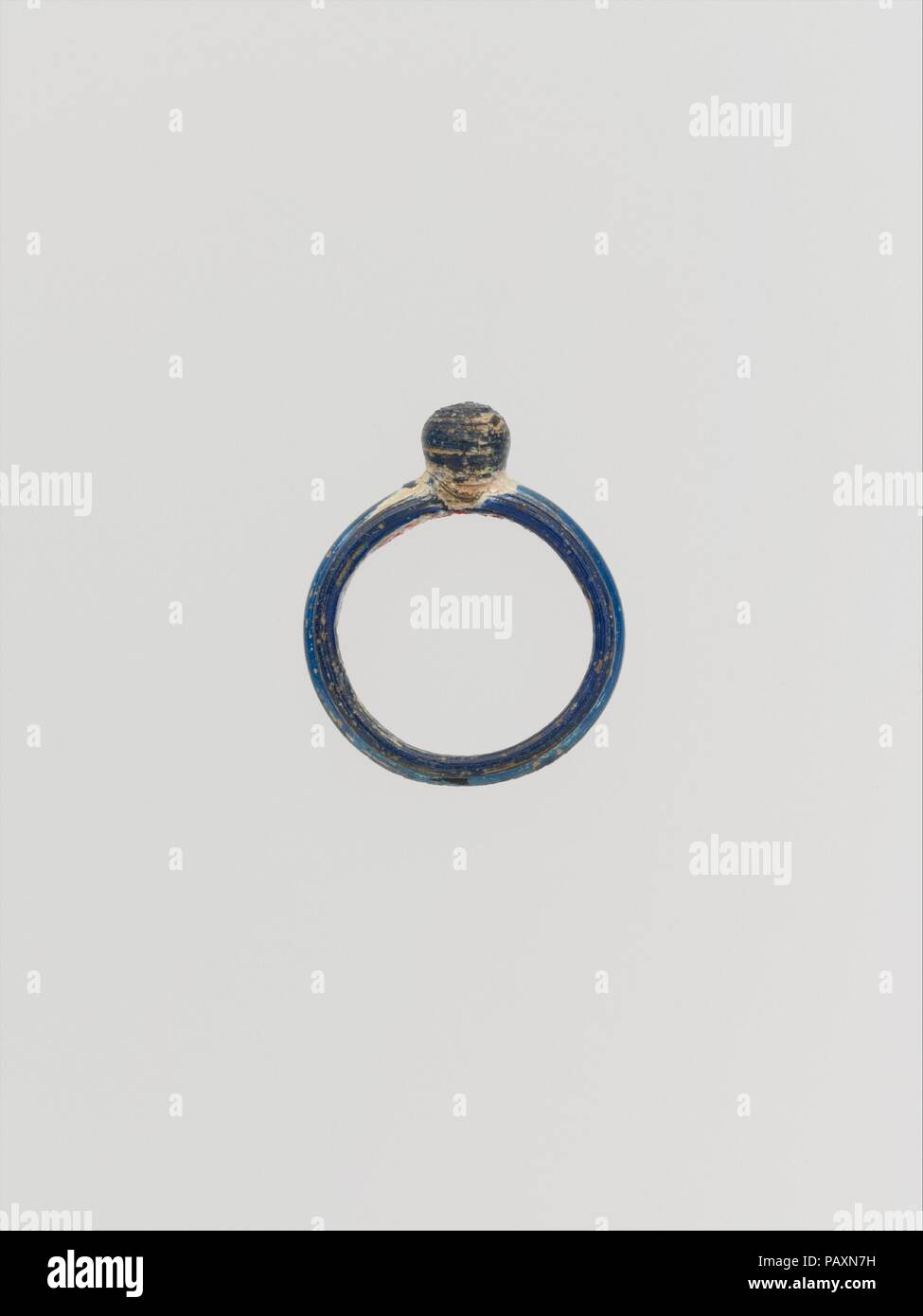 Bague en verre. Culture : Roman. Dimensions : 15/16 × × 1/4 13/16 in. (2,4 × 0,6 × 2 cm). Date : 1er et 2e siècle de notre ère. Bleu cobalt translucide ; lunette de même couleur. Cerceau circulaire, plats en coupe transversale, faite à partir d'une machine et s'est joint à l'écran ; lunette globulaire. Sur l'extérieur d'hoop, quatre nervures horizontales parallèles. Piqûre ; intact ; bulles irisées de piqûres et de l'altération. Musée : Metropolitan Museum of Art, New York, USA. Banque D'Images