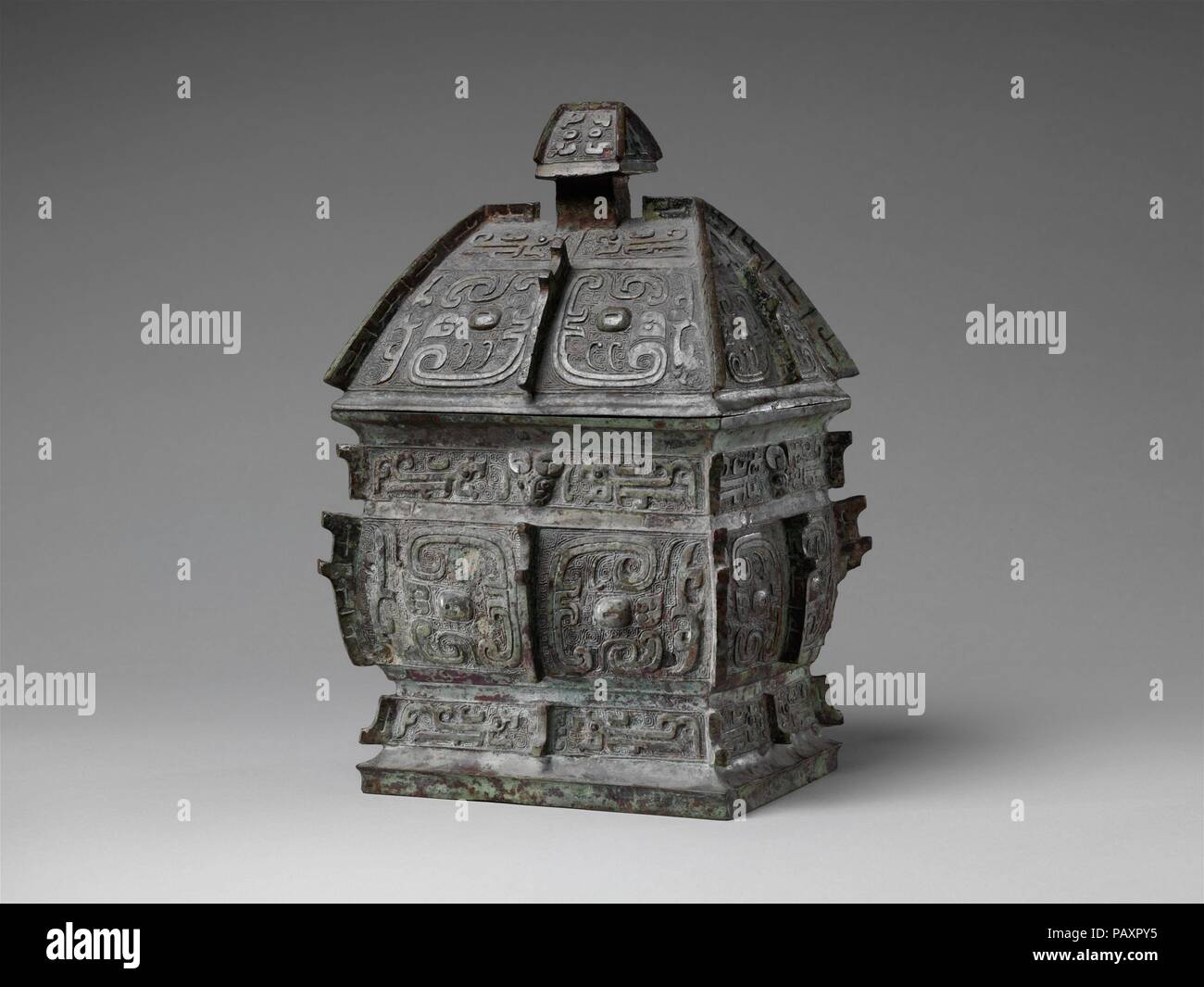 Vin rectangulaire contenant (Fangyi). Culture : la Chine. Dimensions : H. 11 in. (27,9 cm) ; O. 6. (15,2 cm) ; D. 7. (17,8 cm). Date : Mi-10ème siècle avant J.-C.. Au début de la dynastie Zhou de l'Ouest, animal cohérent masquer des images de plus en plus transformé en motifs abstraits définis par les courbes, les lignes en forme de ruban. Un caractère composé est jeté à la fois sur l'intérieur du navire et à l'intérieur du couvercle : 'Fu' (nom, au centre) et 'mian' (désignation de grade, de chaque côté). Musée : Metropolitan Museum of Art, New York, USA. Banque D'Images