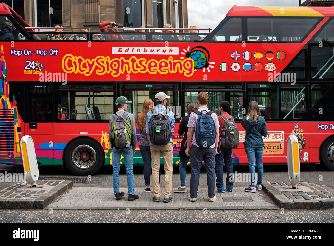 Edinburgh bus de tourisme en passant d'un groupe de touristes attendant de traverser la route à Édimbourg, Écosse, Royaume-Uni. Banque D'Images