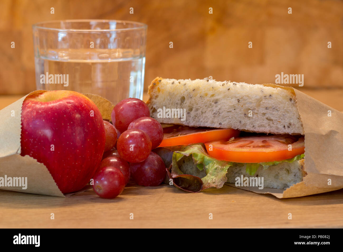 Dîner santé libre de plastique à l'aide d'authentiques du vrai fait maison. Sandwich tomates, raisins, pommes et verre d'eau. Banque D'Images