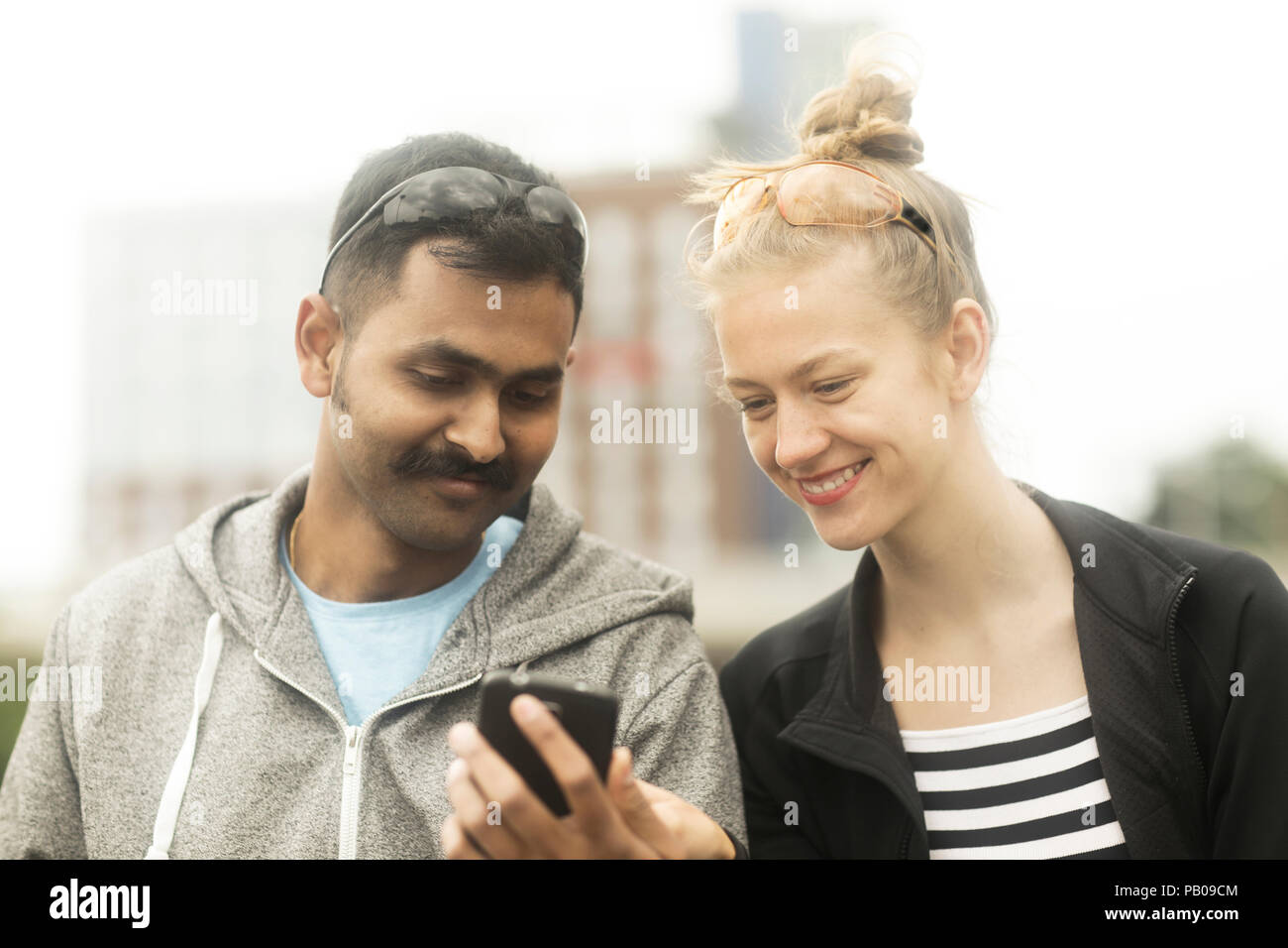 Smiling couple looking at un téléphone mobile Banque D'Images