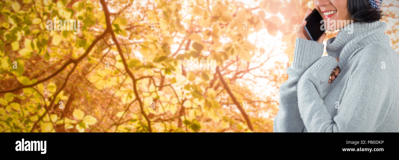 Image composite de femme en vêtements d'hiver talking on mobile phone Banque D'Images