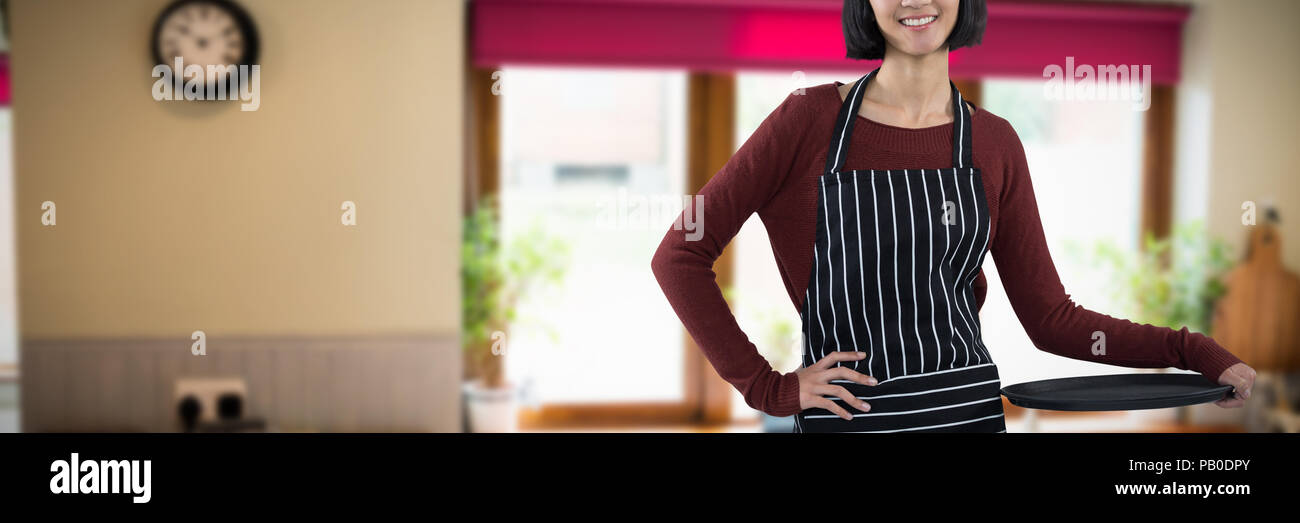 Image composite de smiling waitress holding bac vide contre fond blanc Banque D'Images