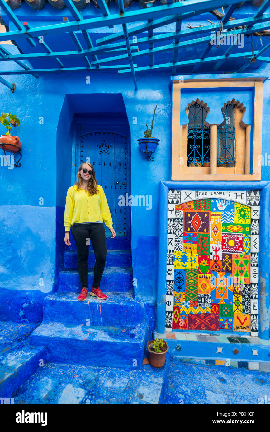 Jeune femme en face d'une maison, les murs de la chambre bleue, Médina de Chefchaouen, Chaouen, Tangier-Tétouan, Royaume du Maroc Banque D'Images