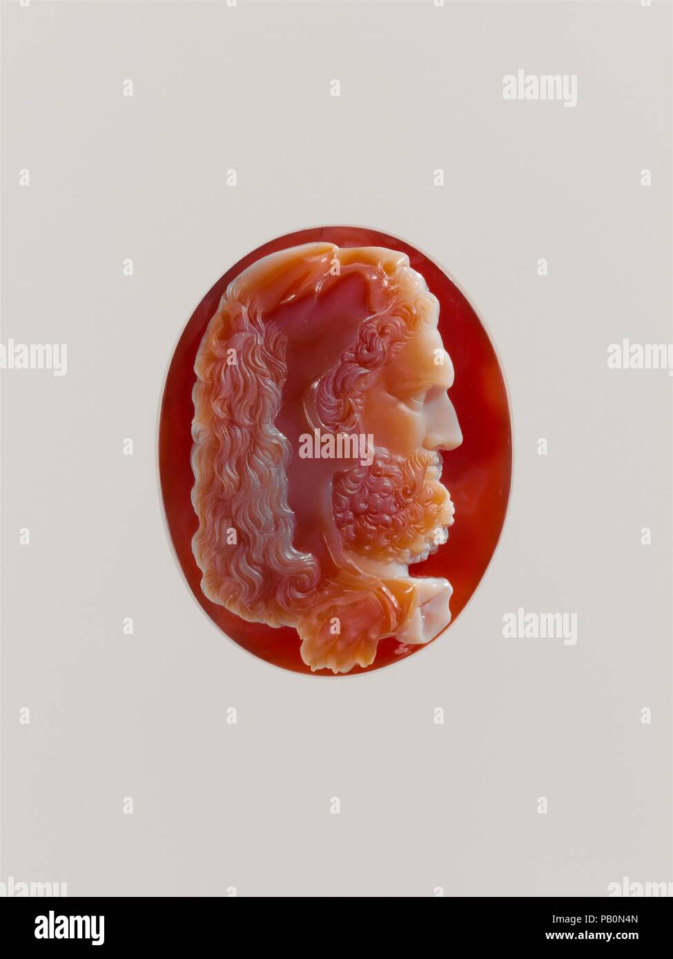 Chef de Hercules. Culture : l'italien, probablement à Rome. Dimensions : hors tout (confirmé) : 2 x 2 9/16 in. (6,5 x 5,1 cm) ; 64,8 x 51,1 x 14,8 mm. Date : milieu du xixe siècle. La tête d'Hercule encadrée dans un casque formé par les mâchoires ouvertes de le lion de Némée, l'animal mort's paws nouée autour du cou, était un aliment de glyptique néoclassiques inspirés par les vieilles pierres précieuses et de pièces de monnaie (voir aussi 40.20.37). Au sein du format l'infini pourrait apparaître. Les deux cette sculpture et 40.20.48 ont trois strates. Le sculpteur anonyme, qui a choisi une pierre pour fiery il a même été dit à tort d'être colorées artificiellement, manipul Banque D'Images