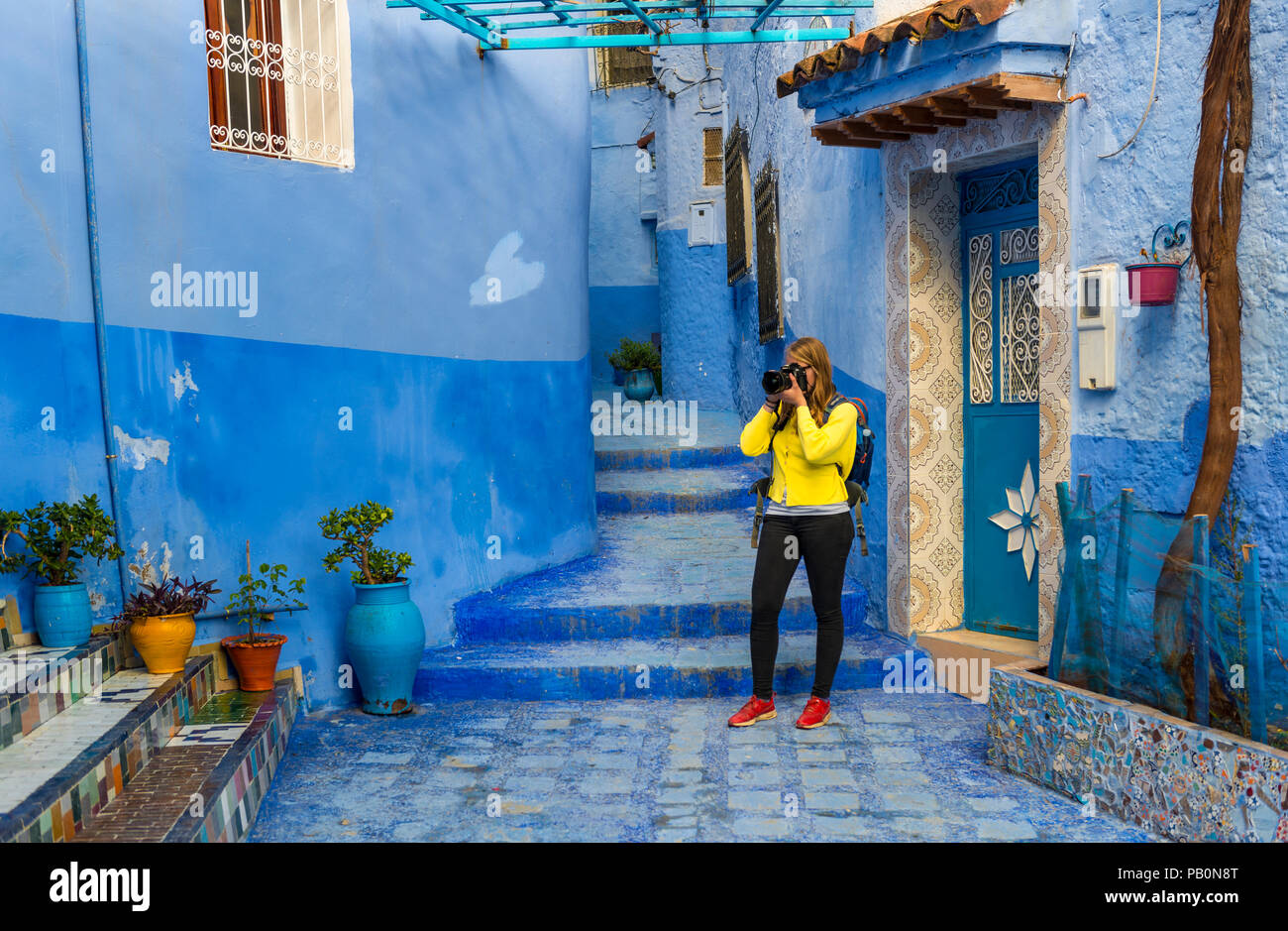 Jeune femme photographiée, Bleu murs de maison, Médina de Chefchaouen, Chaouen, Tangier-Tétouan, Royaume du Maroc Banque D'Images