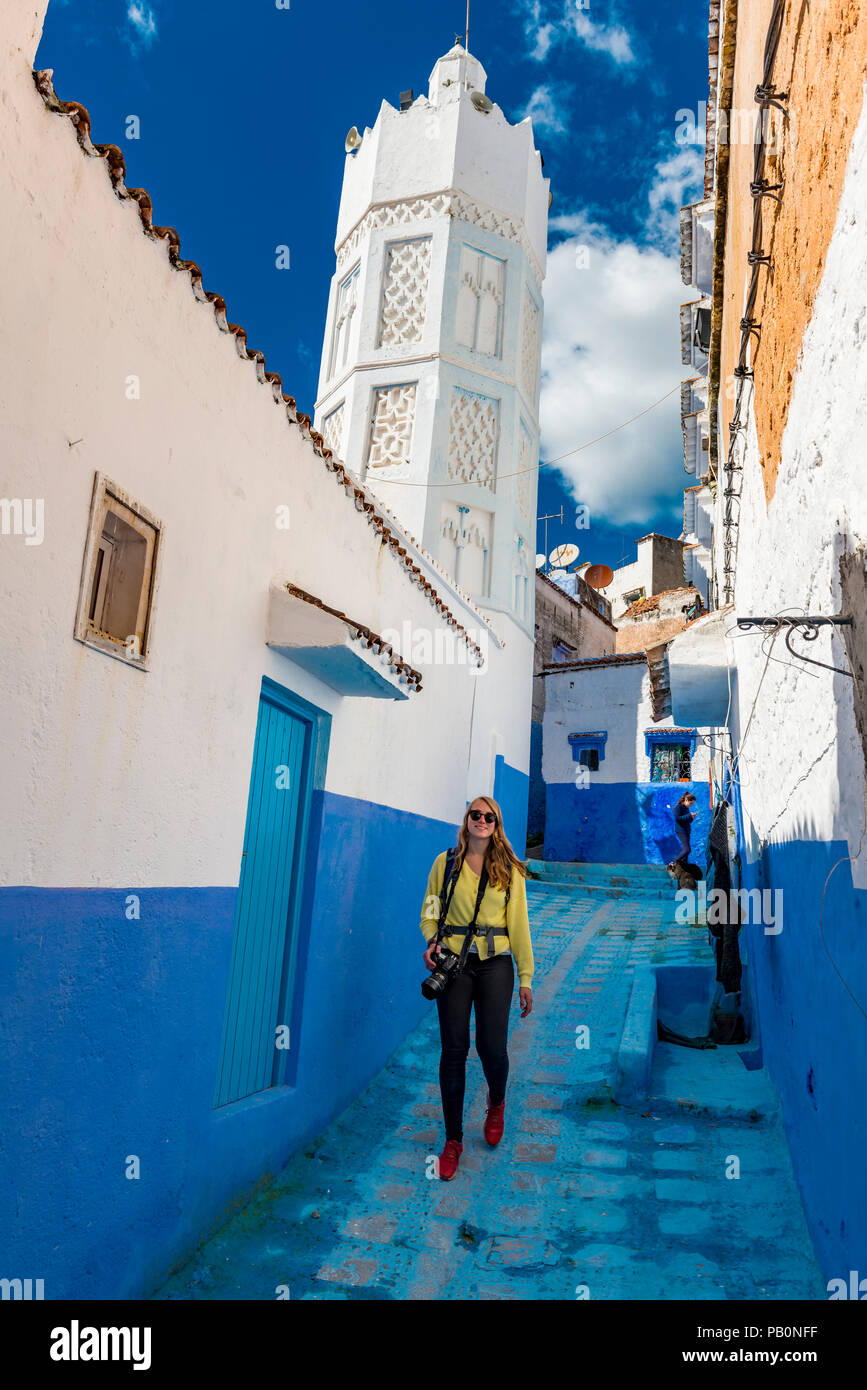 Jeune femme dans la vieille ville en face d'une mosquée, Bleu murs de maison, Médina de Chefchaouen, Chaouen, Tangier-Tétouan Banque D'Images