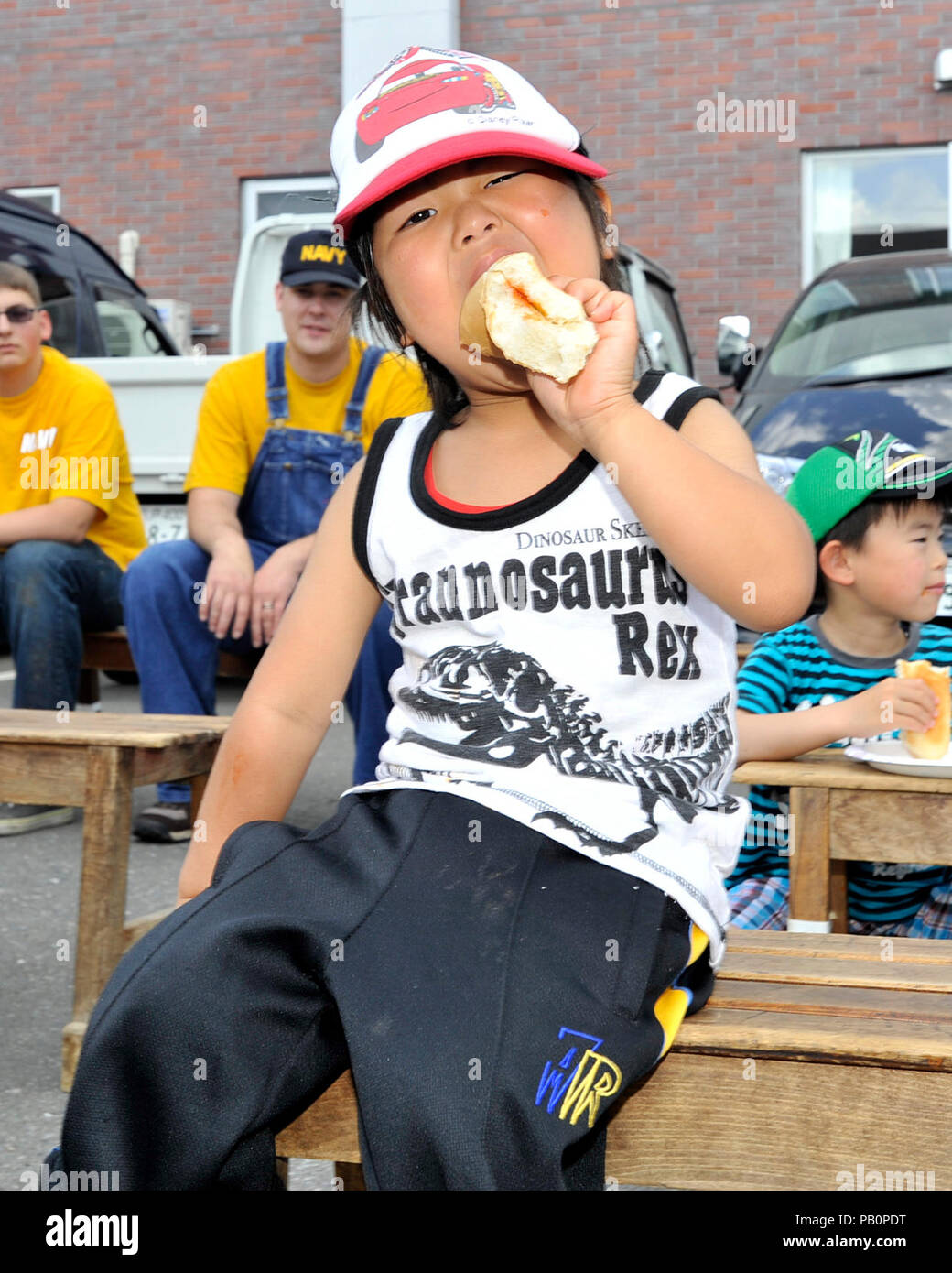 Un jeune résidant de la Biko-en enfants House bénéficie d'un hot-dog au cours d'un événement parrainé par relations communautaires Naval Air Facility (NAF) Misawa, Japon, le 28 juin, . Un jeune résidant de la Biko-en enfants House bénéficie d'un hot-dog au cours d'un événement parrainé par relations communautaires Naval Air Facility (NAF) Misawa, Japon, le 28 juin 2014. Les marins à la NAF Misawa et son locataire et commandes déployés a passé la journée à nettoyer et d'embellir le nord du Japon-situé à orphelinat. Banque D'Images