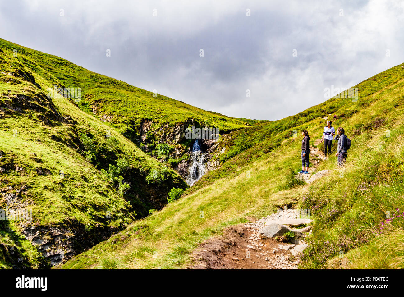 Les randonneurs s'est arrêté sur le chemin pour admirer la cascade de la queue gris mares dans les collines de Moffat, Dumfries & Galloway, Scotland, UK. Banque D'Images