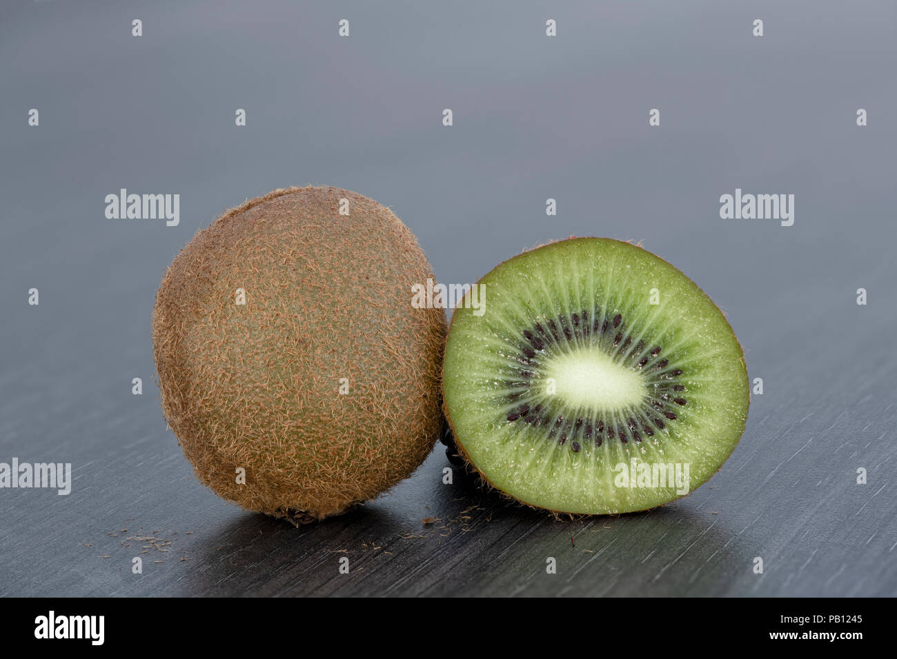 Close up de l'un ensemble et d'un Kiwi tranché sur un plan de travail de cuisine gris clair Banque D'Images