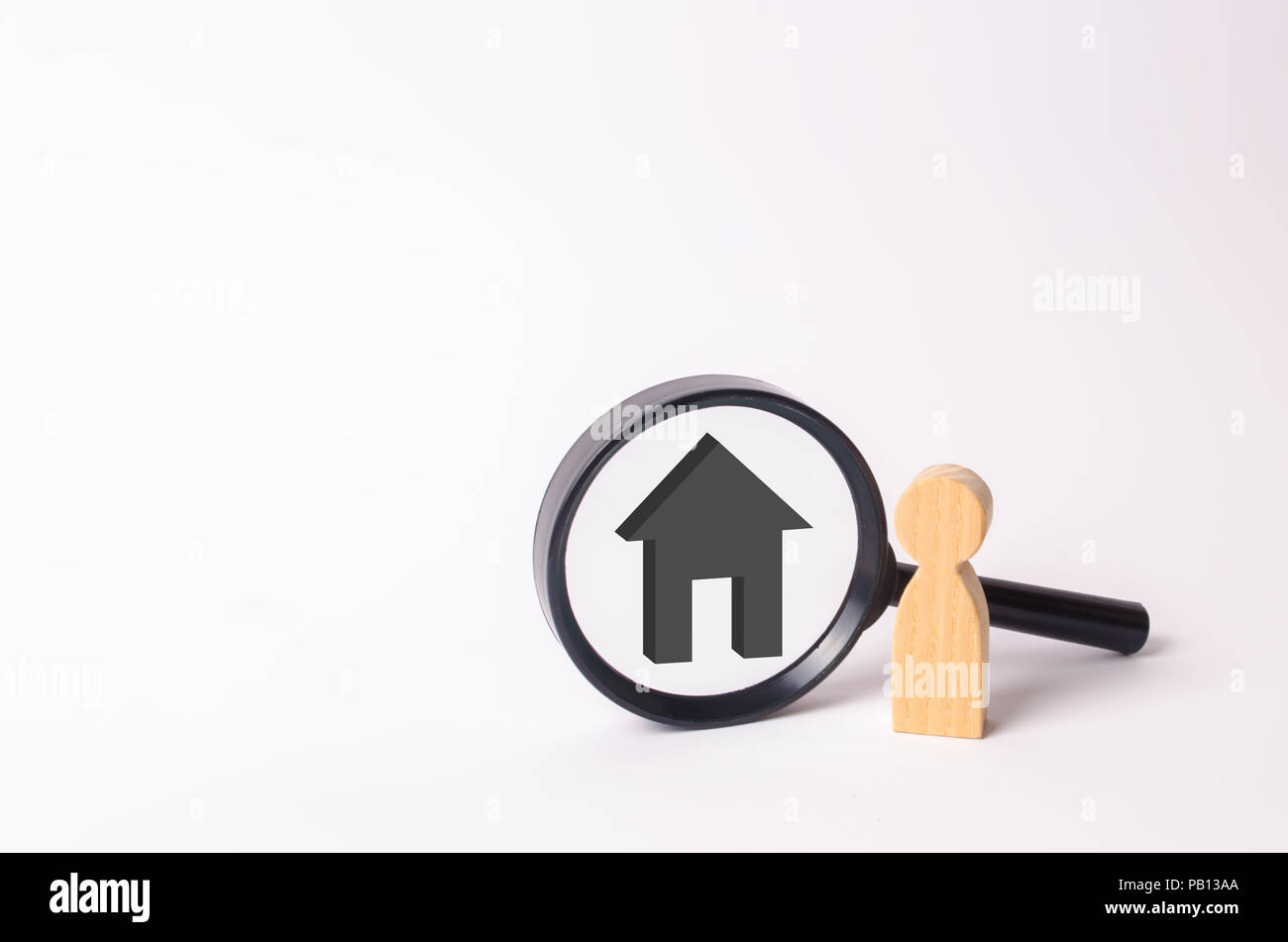 Figures en bois de personnes se tenir près de la loupe avec une maison grise. La famille est à la recherche de quelque chose. Le concept de recherche de logement. Market Banque D'Images