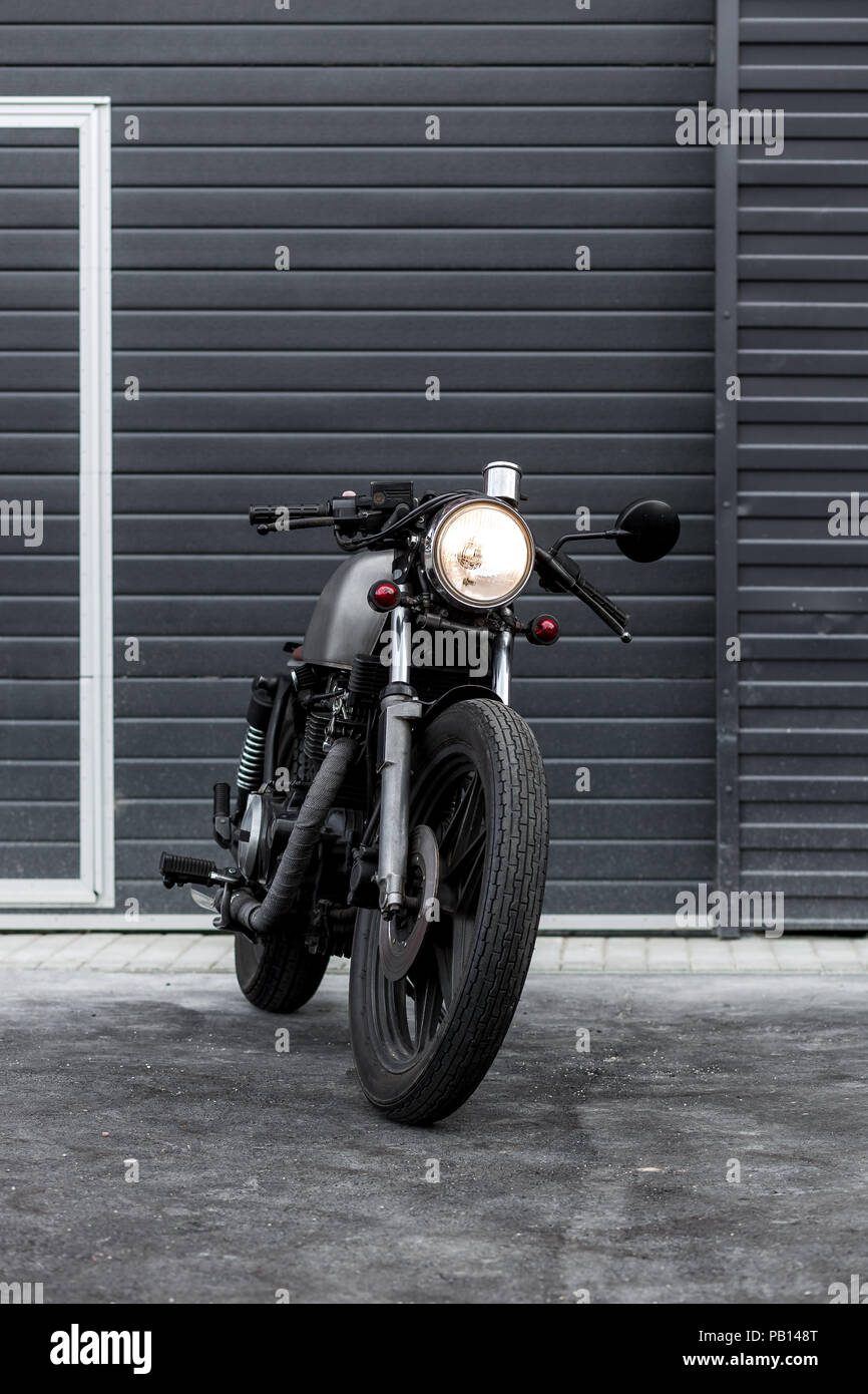 Custom motorcycle parking près de bâtiment industriel noir. Tout est prêt pour le plaisir de conduire le vide, sur une moto tour voyage. Hanches Banque D'Images