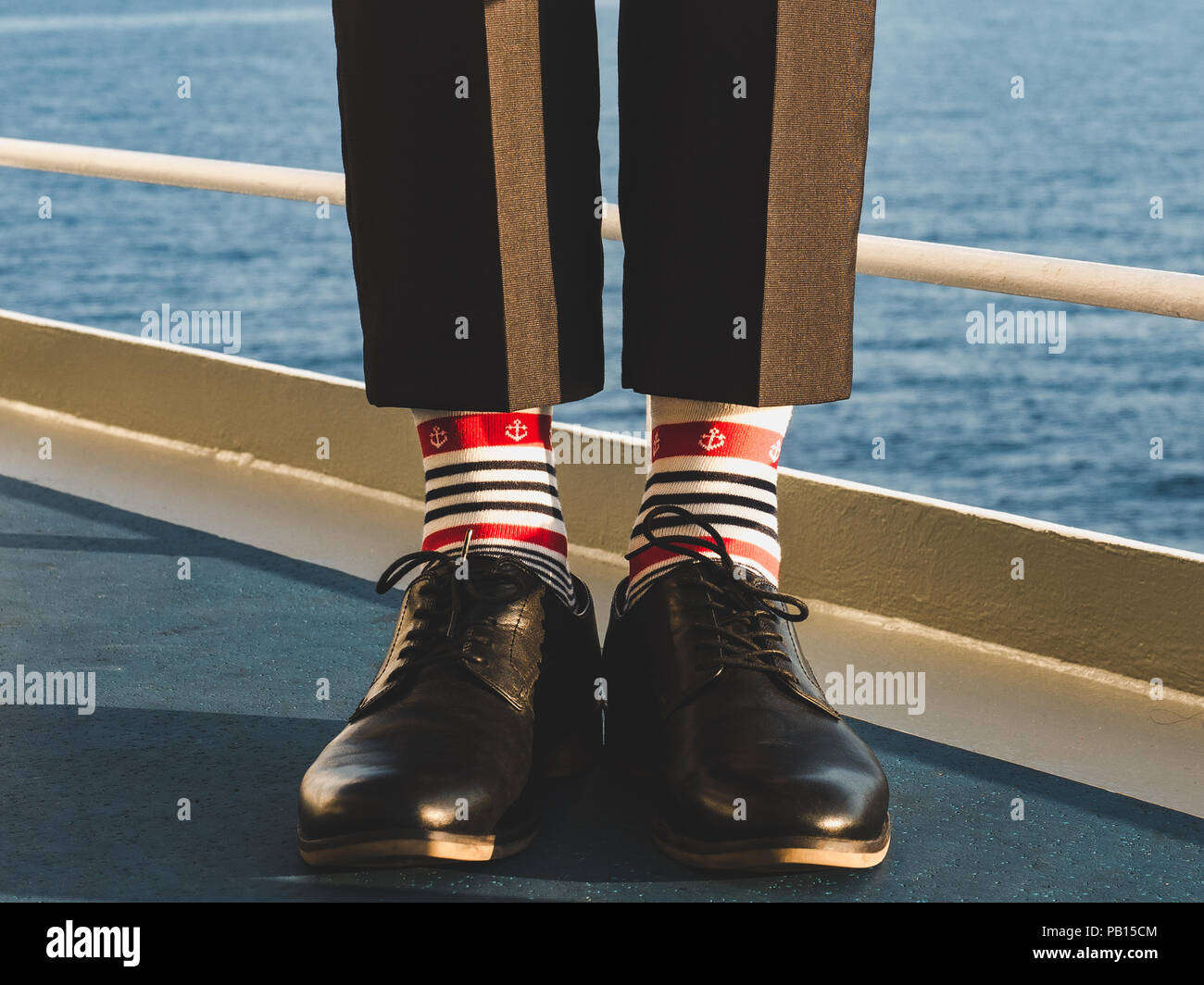 Dans l'homme élégant, chaussures noires, pantalon foncé et brillant, drôle,  chaussettes rayées avec un motif sur le pont d'un navire de croisière.  Lifestyle, Fashion, fun Photo Stock - Alamy
