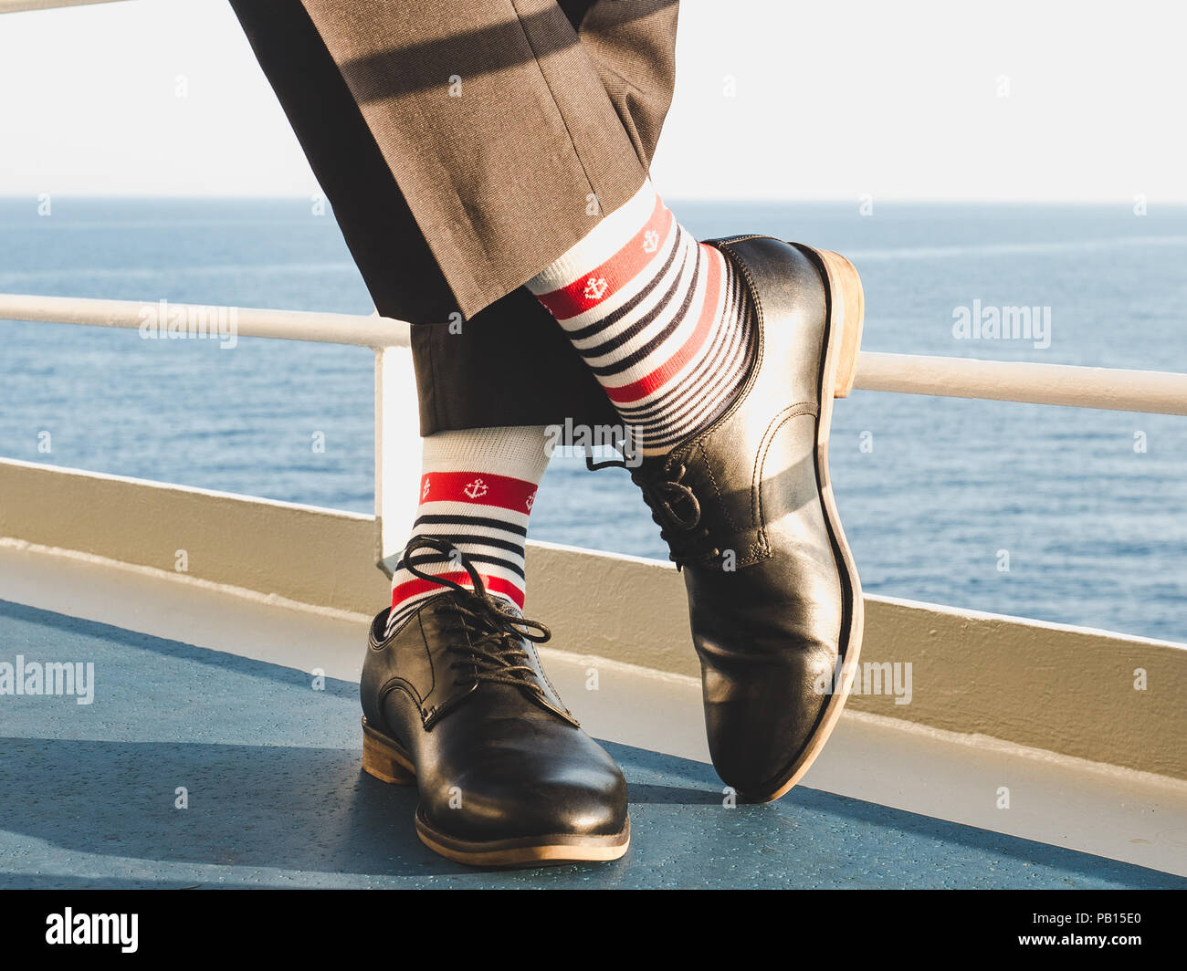 Dans l'homme élégant, chaussures noires, pantalon foncé et brillant, drôle,  chaussettes rayées avec un motif sur le pont d'un navire de croisière.  Lifestyle, Fashion, fun Photo Stock - Alamy