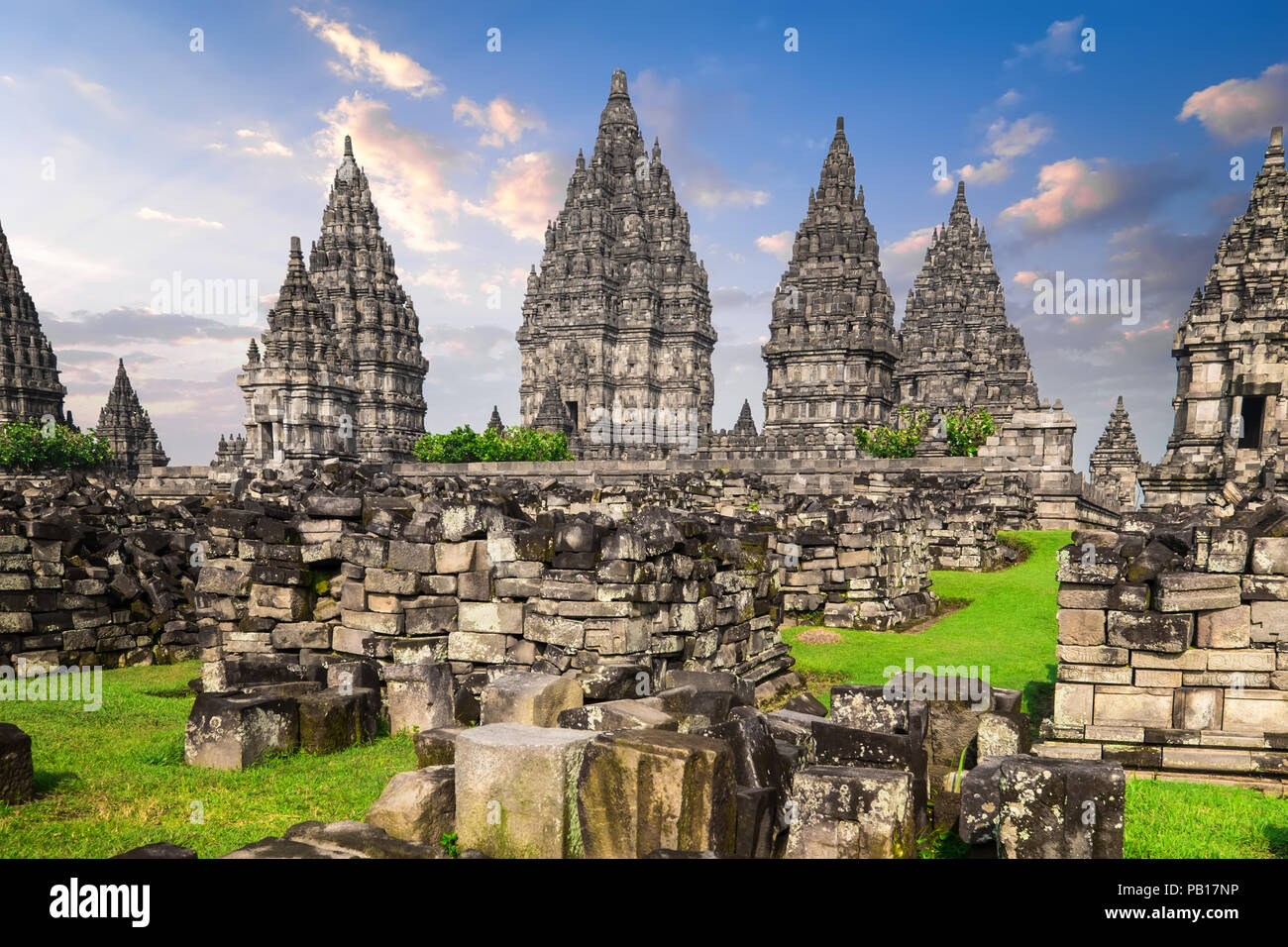 Ancienne bergerie en ruines sur champ vert et Candi Prambanan ou Rara Jonggrang, temple hindou composé sur l'arrière-plan. Site architectural impressionnant. Yogyakar Banque D'Images