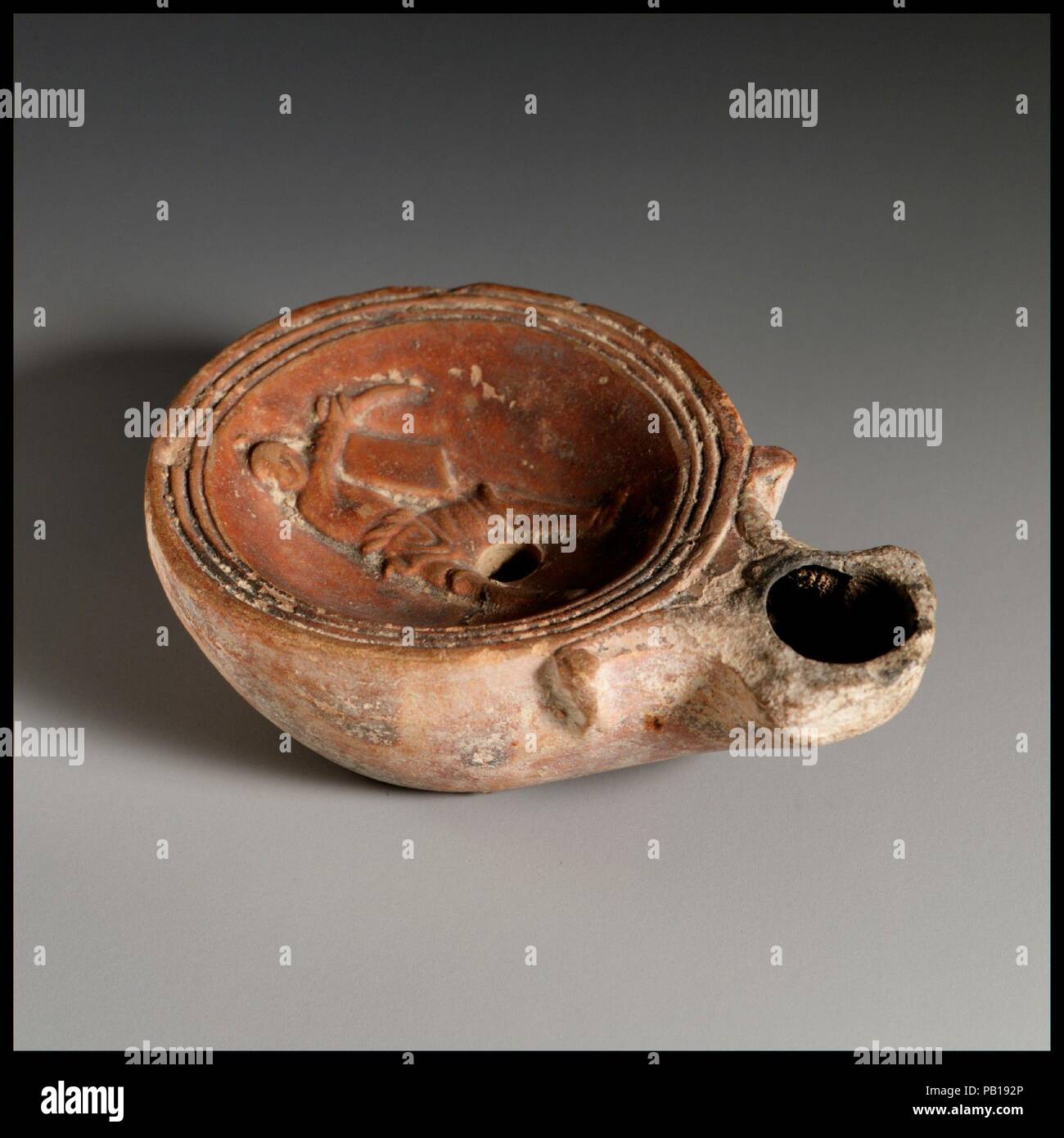 Lampe à huile en terre cuite. Culture : Roman, chypriote. Dimensions : hors tout : 1 x 3 1/8 in. (2,5 x 7,9 cm). Date : ca. La C.-B. 20-A.D. 25. Type Loeschcke 1A. Faites-moule. Discus : gladiator debout face à l'avant, le port de casque et Greaves, holding petite place la protection en court et courbé gauche, épée en main droite, avec un groupe de lignes et les rainures vers le bord. Volutes flanquant la buse. À l'intérieur de base surélevée, anneau de base légèrement inégale, avec l'ensemble de lettres impressionnés centre : FAVSII. Intacts. Musée : Metropolitan Museum of Art, New York, USA. Banque D'Images