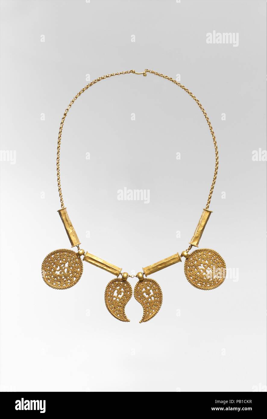 Collier en or avec un pendentif. Culture : Byzantine. Dimensions : hors tout : 21 5/8 x 1 15/16 x 3/8 in. (55 x 4,9 x 0,9 cm) chaîne d'hôtels : 21 5/8 po. (55 cm) : perles de forme hexagonale 1 7/16 x 3/8 in. (3,6 x 0,9 cm) : médaillons 1 15/16 x 1 1/2 x 1/4 in. (4,9 x 3,8 x 0,7 cm) en forme de pétale pendentifs : 1 7/8 x 1 x 1/4 in. (4,7 x 2,6 x 0,7 cm). Date : ca. 7e siècle. Les pendentifs finement travaillé sont séparées par des entretoises. L'Opus interrasile est une technique utilisée par les orfèvres de faire élégant bijoux de la 200s à travers les 600s. Dessins et modèles industriels ont été retrouvées à des feuilles d'or, l'arrière-plan a été frappé avec Banque D'Images