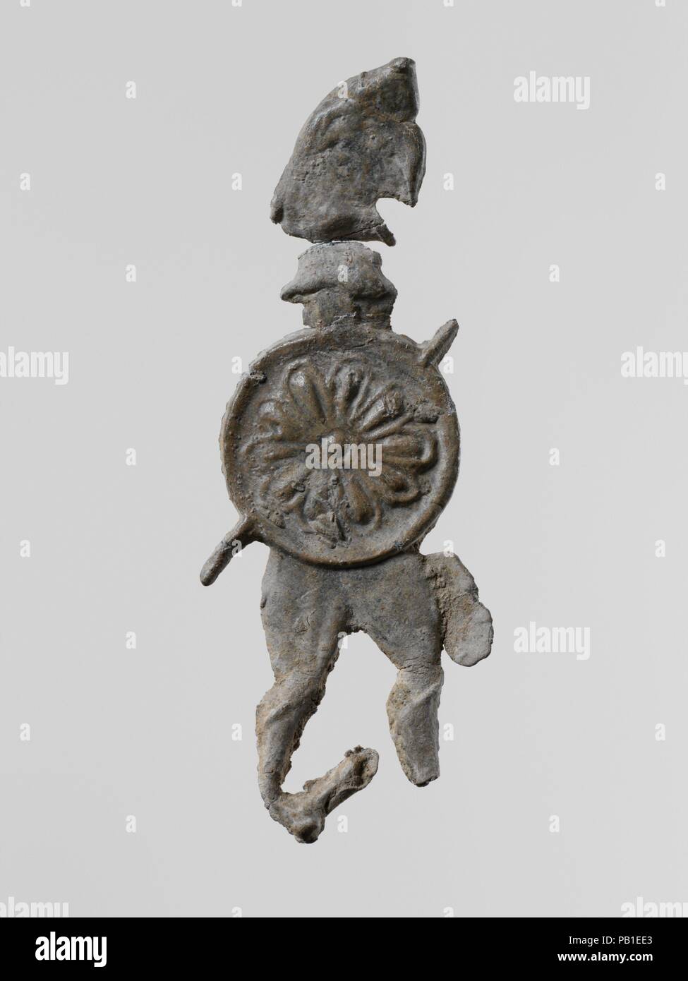 Conduire la figure d'un guerrier avec un casque et un bouclier. Culture : le grec, le Laconien. Dimensions : Hauteur : 2 1/2 in. (6,4 cm). Date : 6ème-5ème siècle avant J.-C.. Petit figurines votives de plomb durci ont été trouvés en grande quantité, à l'ancienne des sanctuaires de la Laconie ; plus de cent mille, datant du viie siècle avant J.-C. à l'époque classique, ont été dédiés à la déesse Artémis Orthia à Sparte. Musée : Metropolitan Museum of Art, New York, USA. Banque D'Images