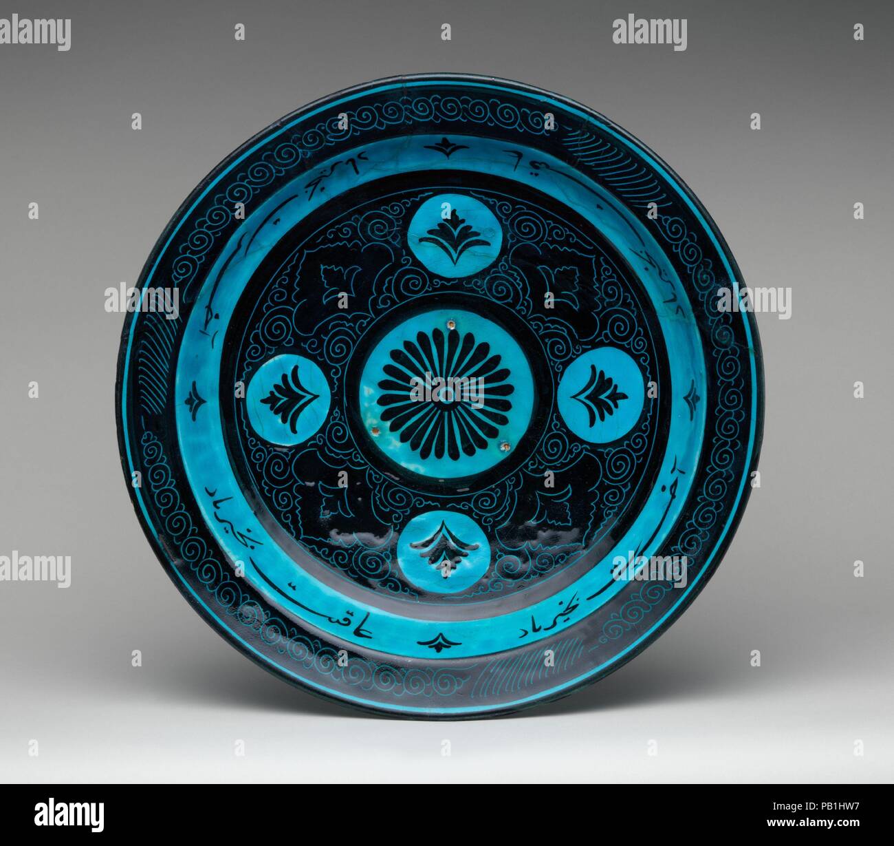 Le plat. Dimensions : 14 1/2 po. (36,8 cm). Date : seconde moitié du 15ème siècle. Cette substitution, turquoise et noir bol appartient à un groupe de la céramique connue sous le nom de Kubachi ware. Le nom d'un village dans le Caucase où cette poterie a été découvert en quantité, Kubatchi marchandises peut avoir été produit ailleurs dans le nord-ouest de l'Iran. Ce bol-- peint en noir sous glaçure turquoise pâle, avec un motif incisé de spirales et d'éléments floraux--est parmi les premiers exemples. Le bol affiche une inscription de vœux de bonne fortune. Musée : Metropolitan Museum of Art, New York, USA. Banque D'Images