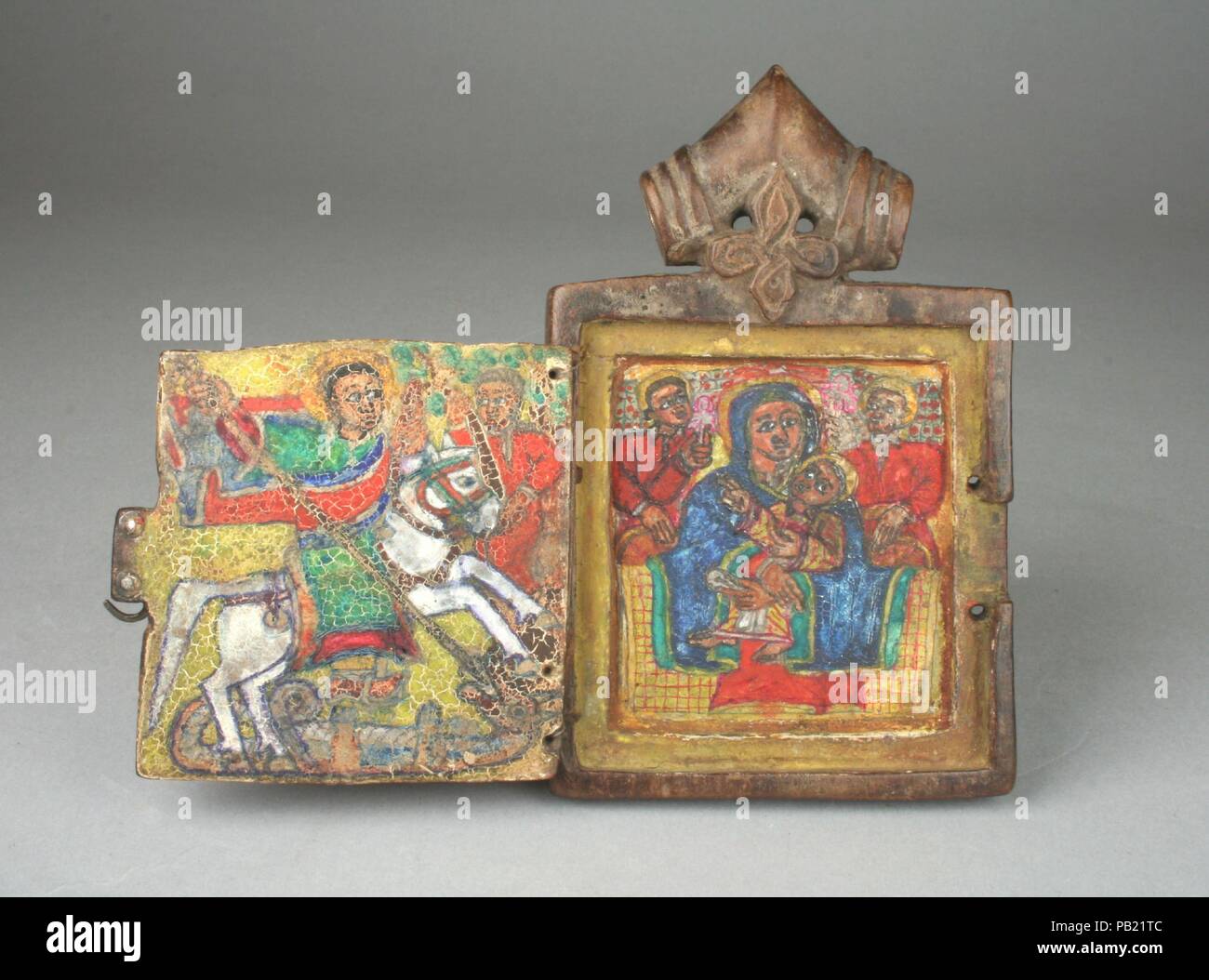 Icône pendentif : Saint Georges, vierge et l'enfant ont intronisé. Culture : l'Ethiopien. Dimensions : H. 4 3/4 x 3 1/8 in. W. (12.1 x 7.9cm). Date : le 18e siècle. Cette poignée de échelle intime et protecteur d'experts externe lui permet d'être utilisé comme une icône personnel portable. La seule face du diptyque cas pourrait être en bois sculpté s'ouvrit pour révéler des peintures de la Vierge Marie et de Saint George, deux des figures les plus populaires dans l'Orthodoxie Christianisme éthiopien. Le creux en forme de V inversé en haut du cylindre lui a permis d'être suspendu de son cou. Un carré entrelacé est sculpté au-dessous de la boucle de l'eac Banque D'Images