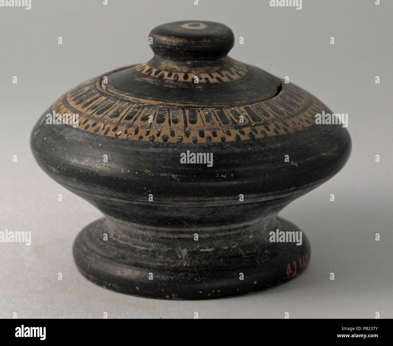 Pyxis ou Kothon. Culture : le grec, le grenier. Dimensions : hors tout : 1 9/16in. (4cm) d'autres (hauteur avec couvercle) : 2 1/16 po. (5.3Cm) Autres (hauteur de la boîte) : 1 9/16in. (4cm) Diamètre : 2 1/4 x 1 9/16 in. (5,7 × 4 cm). Date : 5ème siècle avant JC. Modèle de langue et les points. Musée : Metropolitan Museum of Art, New York, USA. Banque D'Images