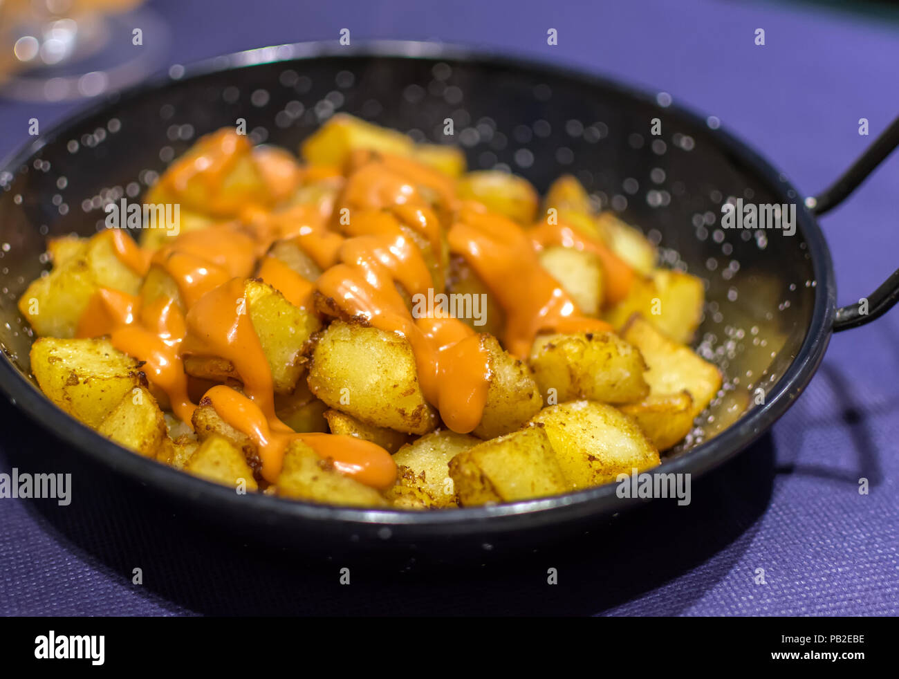 Patatas bravas (pommes de terre) avec l'espagnol de couleur orange épicé (salsa brava brava sauce) ou alioli (aïoli). Patatas Bravas est un classique et très po Banque D'Images