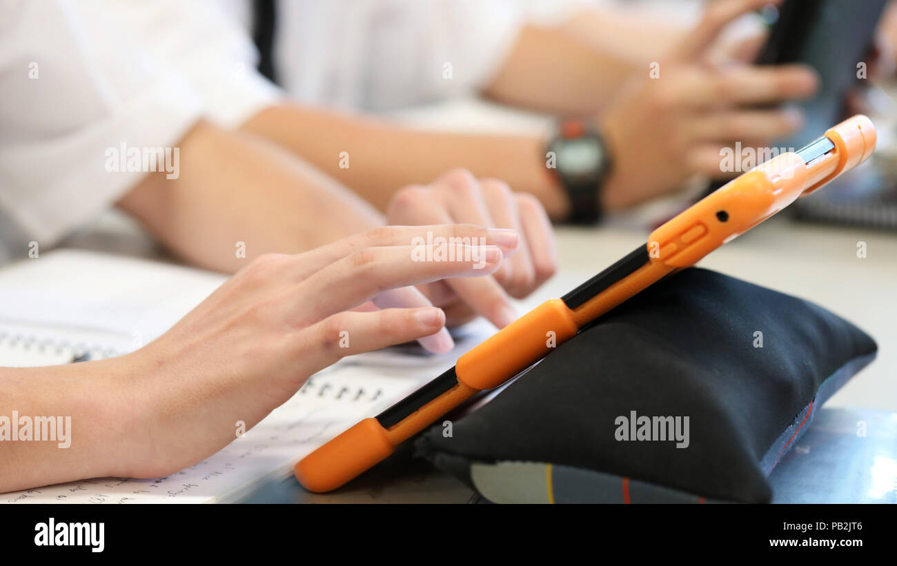 Les élèves du secondaire travaillent sur l'utilisation d'une tablette électronique ipad style ordinateur périphérique. pédagogie moderne et l'enseignement de l'apprentissage dans l'éducation pour l'éducation Banque D'Images