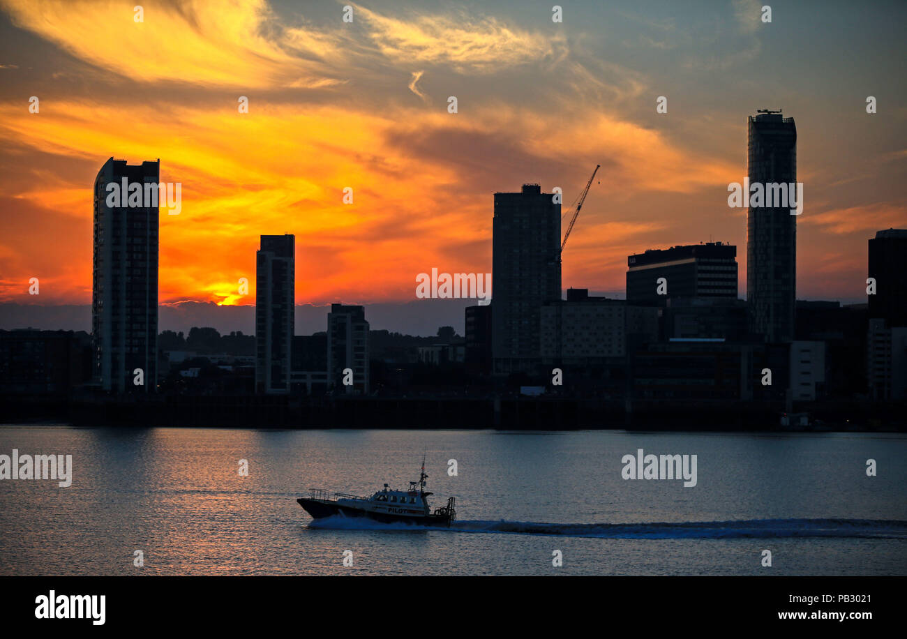 Le soleil se lève derrière la skyline de Liverpool à partir de la gare maritime de Woodside à travers le fleuve Mersey. Les températures devraient atteindre 35°C aujourd'hui que la canicule se poursuit à travers le Royaume-Uni. Banque D'Images