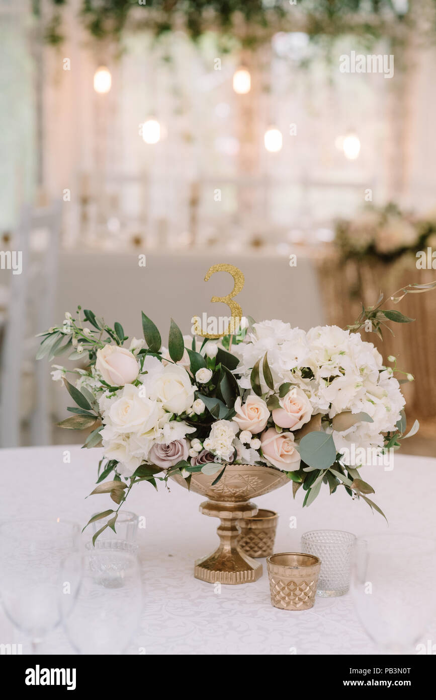 Décoration d'une table de banquet à l'occasion d'un mariage avec des fleurs  dans un vase d'or. De belles fleurs sur une table au restaurant élégant  Photo Stock - Alamy