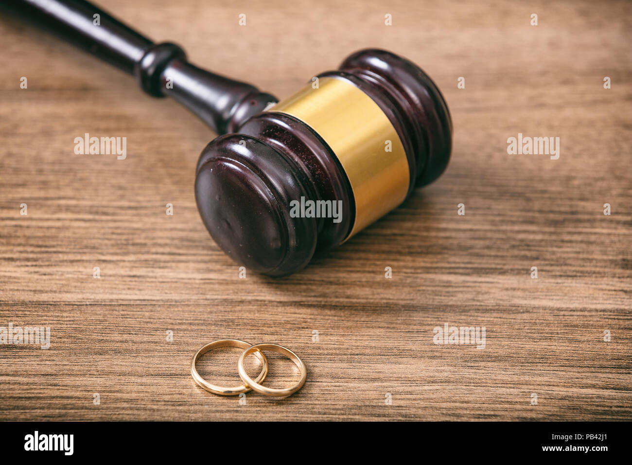 Concept de divorce. Les anneaux de mariage et le juge gavel sur fond de bois, copy space Banque D'Images