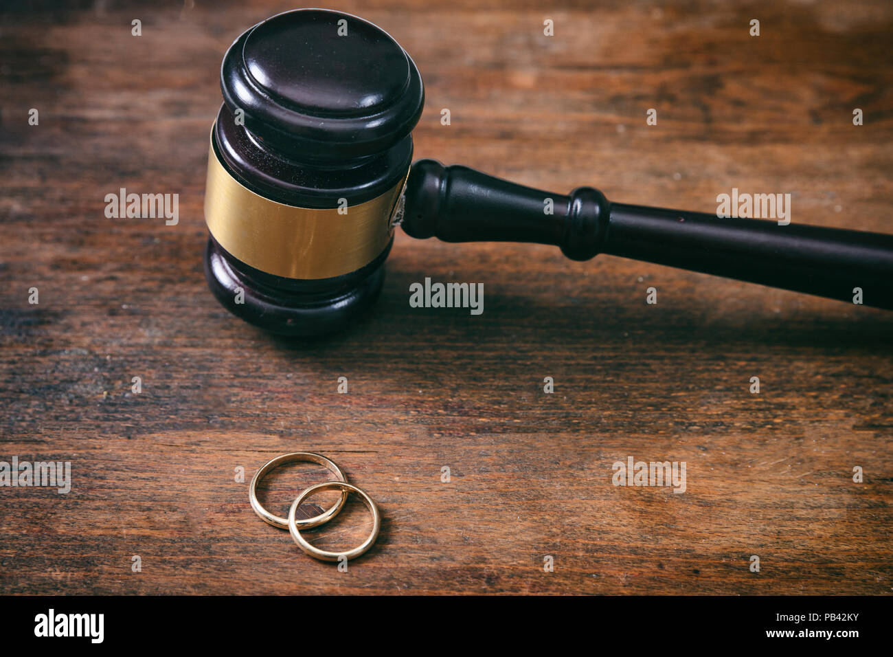 Concept de divorce. Les anneaux de mariage et le juge gavel sur fond de bois, copy space Banque D'Images