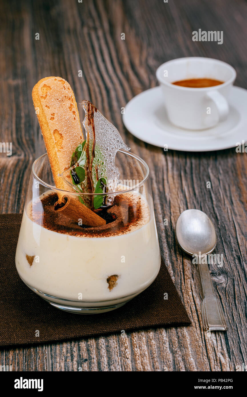 Tiramisu dessert italien décoré avec une tasse de café espresso et une cuillère de table marron Banque D'Images