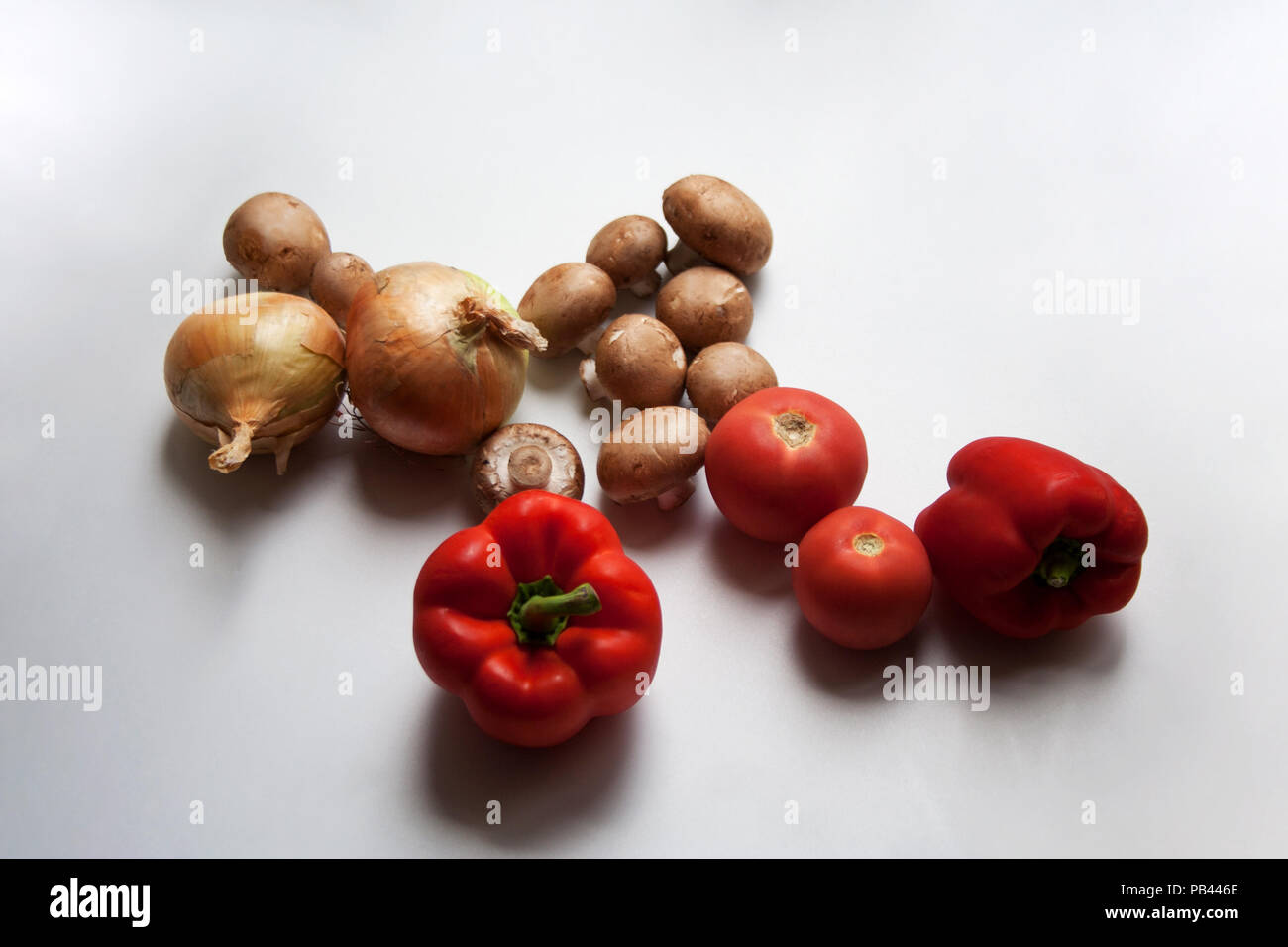 Champignons, oignons, tomates et poivrons rouge isolé sur fond blanc Banque D'Images