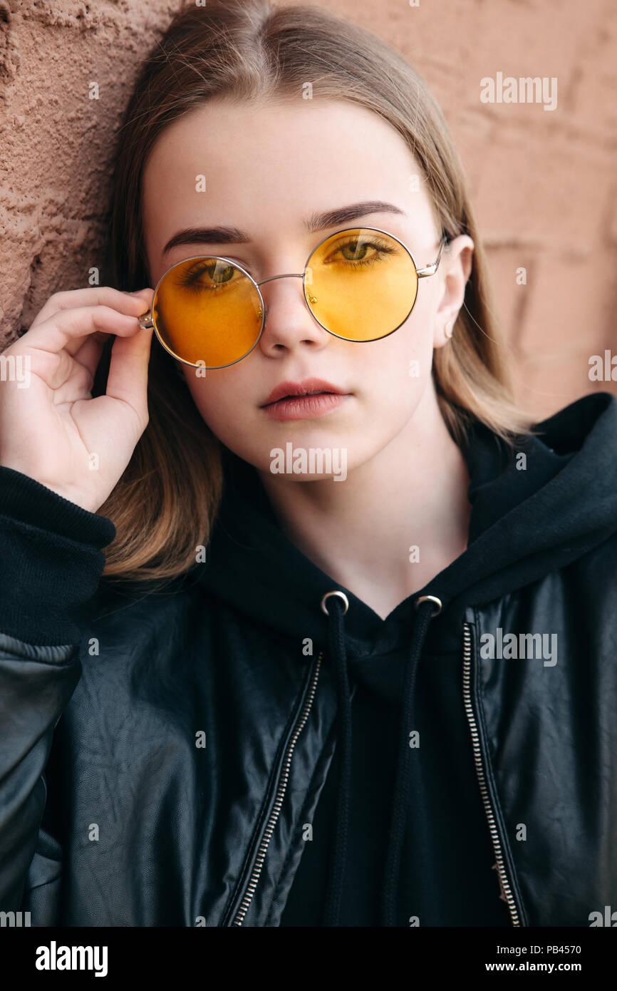 Beau gosse à la mode fille à lunettes jaunes en ville Photo Stock - Alamy