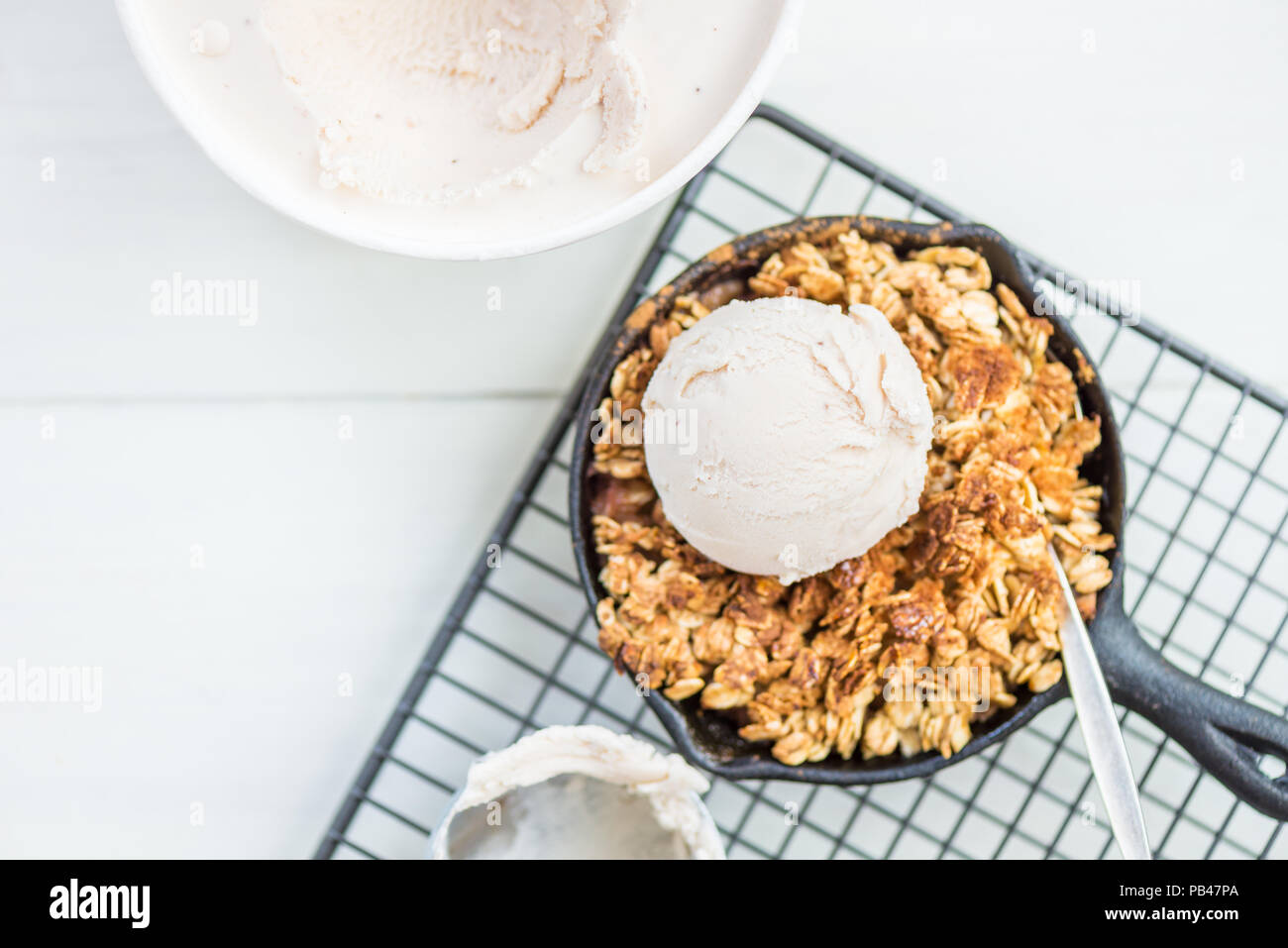La rhubarbe cuite faits maison et crumble aux pommes avec glace à la vanille et à l'avoine dans le fer à repasser Cuisine Banque D'Images