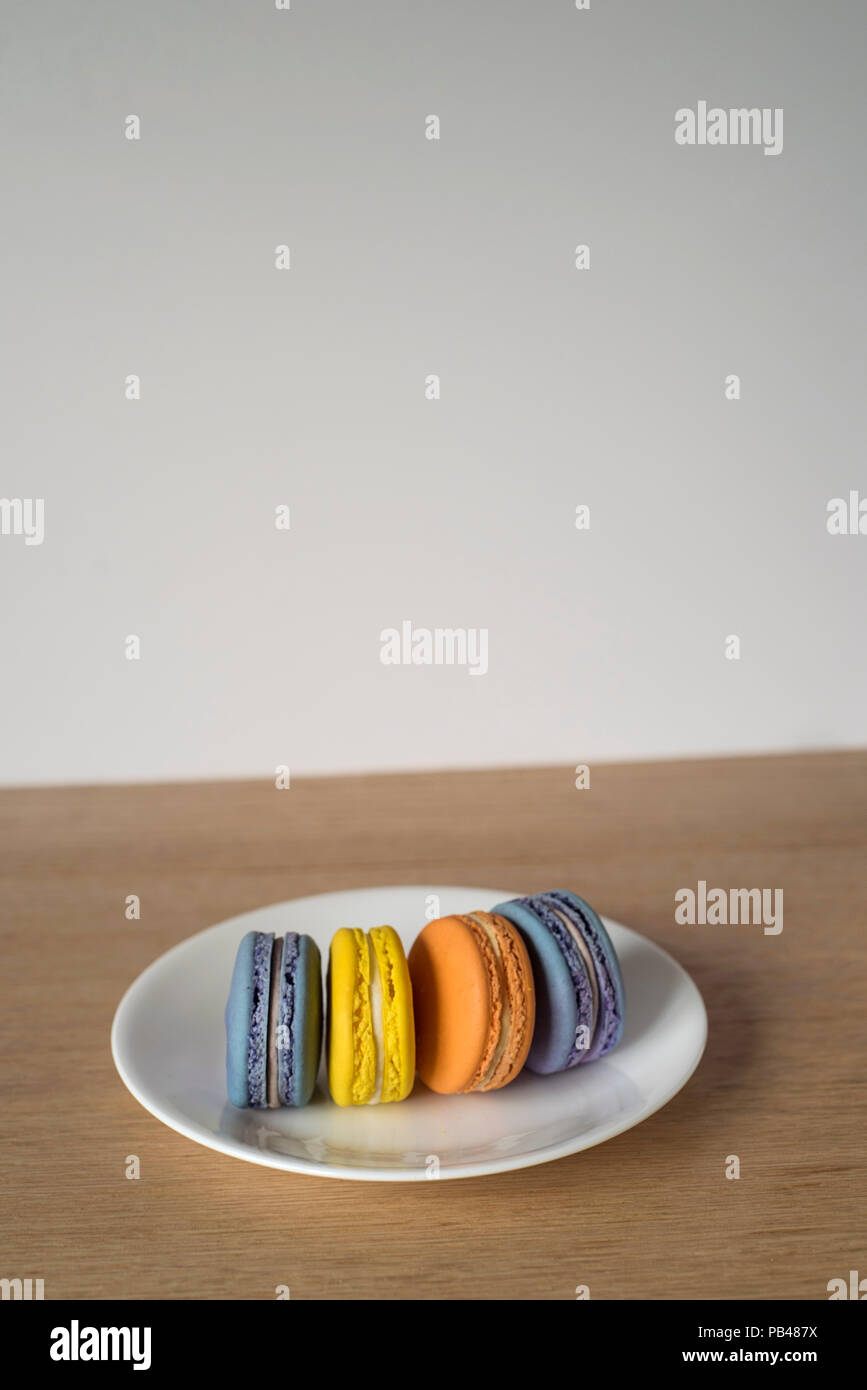 Macarons colorés debout sur une plaque Banque D'Images