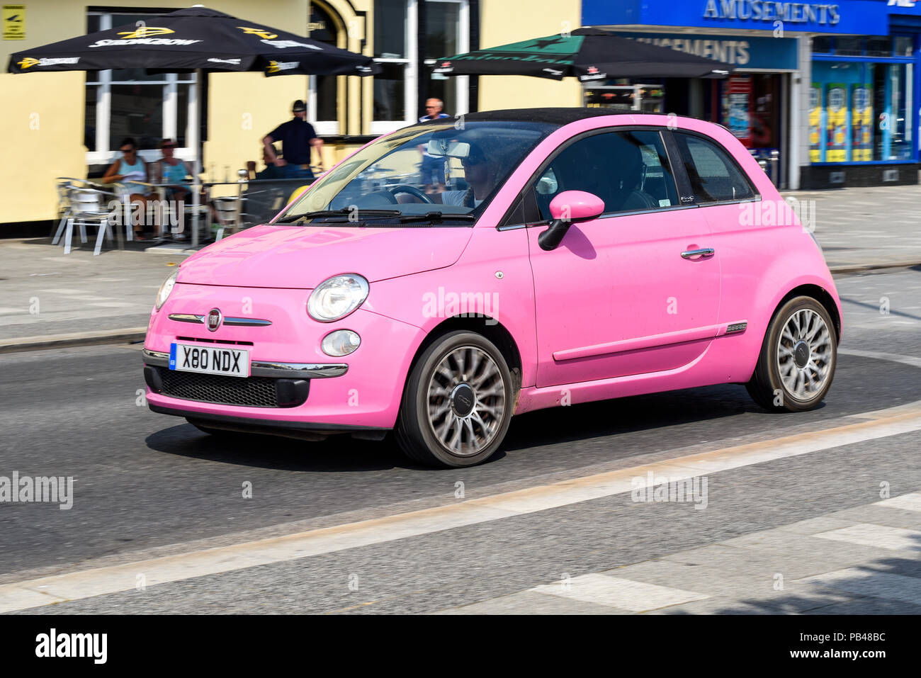 Voiture rose Fiat 500 conduisant sur Marine Parade, Southend sur Sea Seafront, sur la chaude journée ensoleillée d'été. X80 NDX Banque D'Images