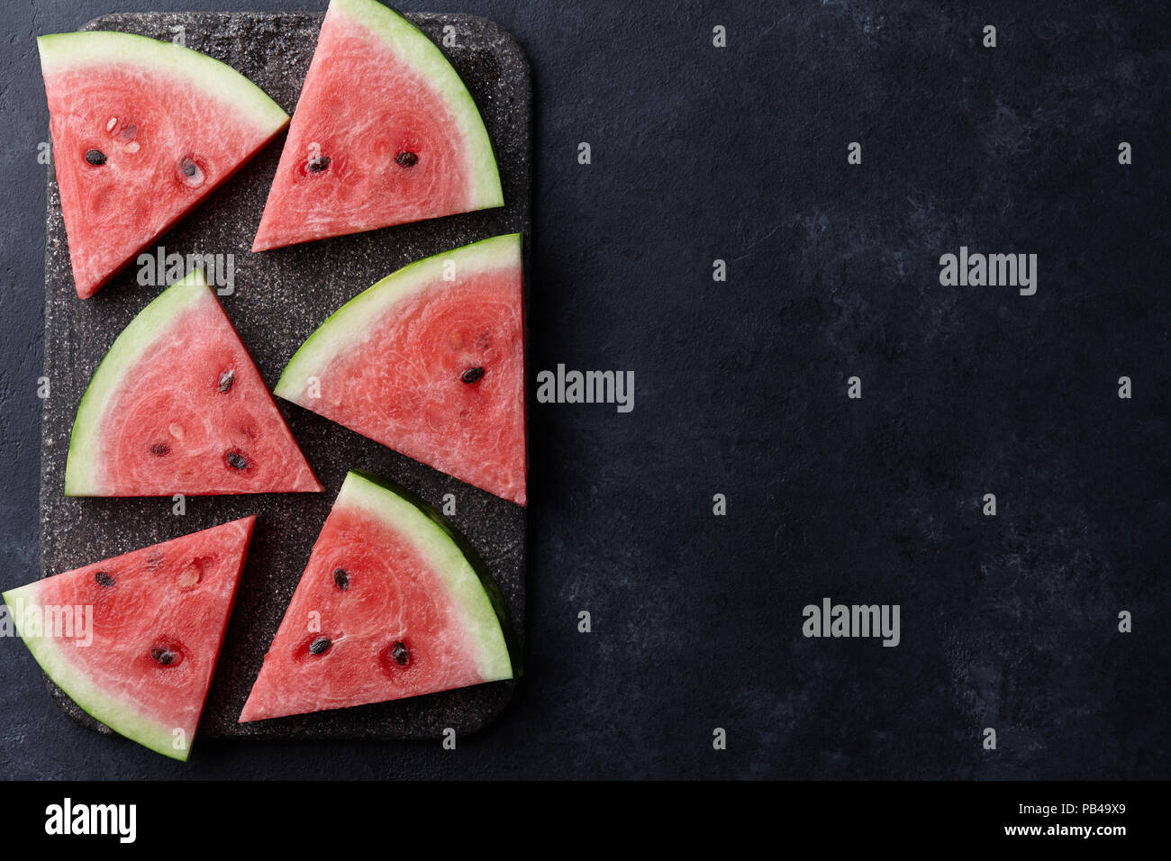 Panneaux colorés frais melon sur fond noir en noir, vue du dessus Banque D'Images