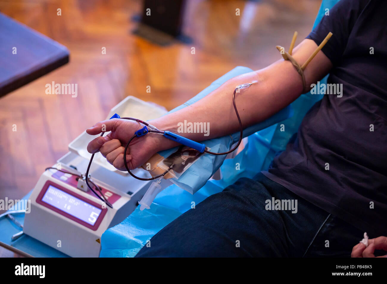 La main d'un homme qui fait don de sang. Donneur mâle donne du sang dans un centre mobile de prélèvement du sang. Des échantillons de sang. Banque D'Images