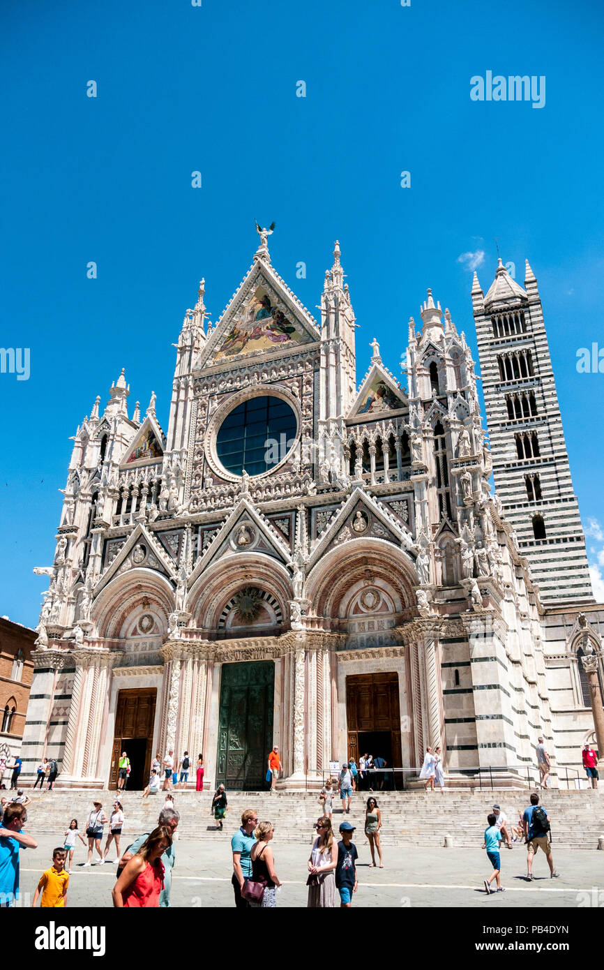 Personnes regardant l'avant de la cathédrale gothique de Santa Maria Assunta, dans la ville médiévale de Sienne, Toscane, Italie Banque D'Images