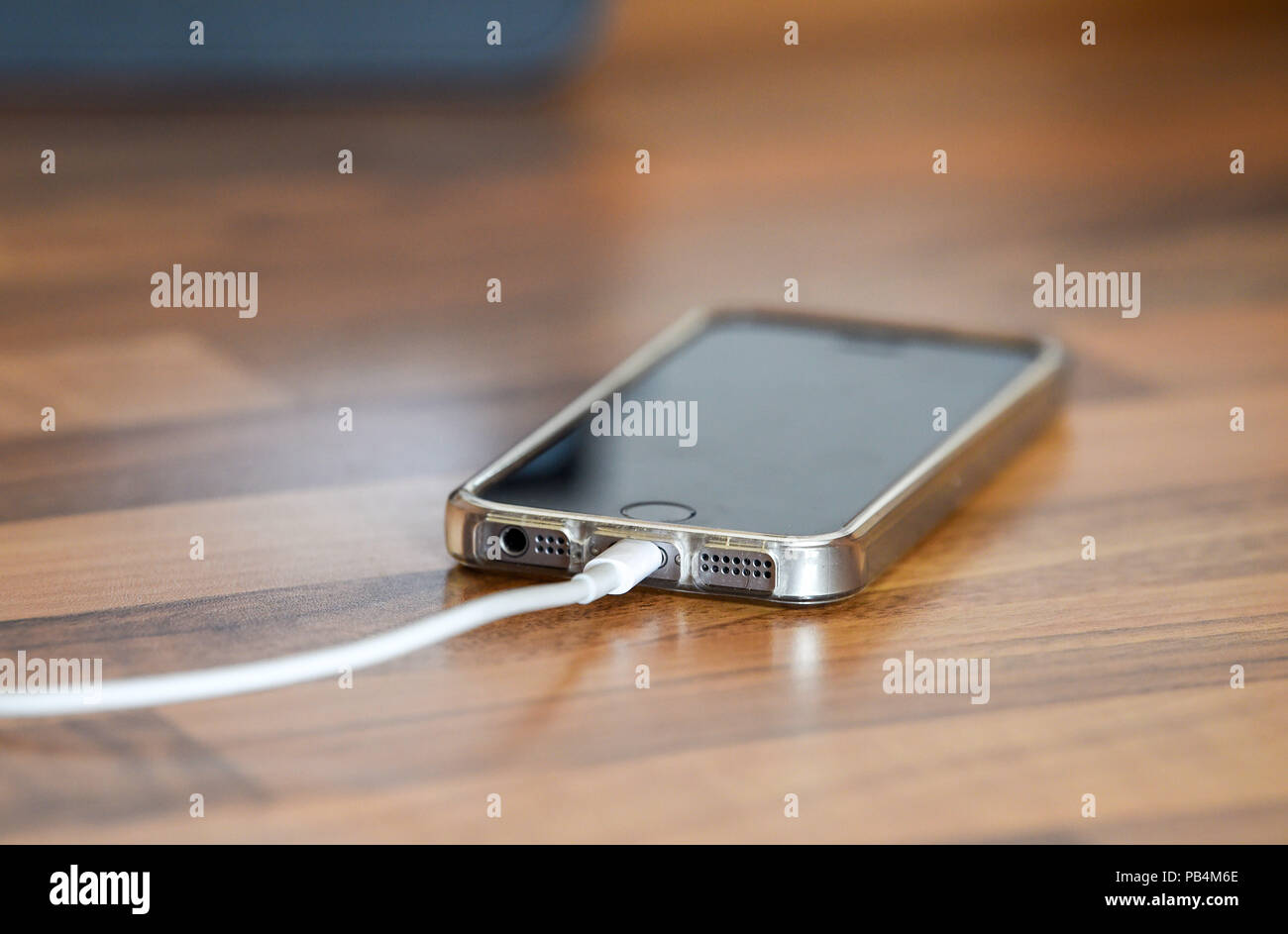 Apple iPhone SE étant chargé jusqu'à côté d'une radio DAB Banque D'Images