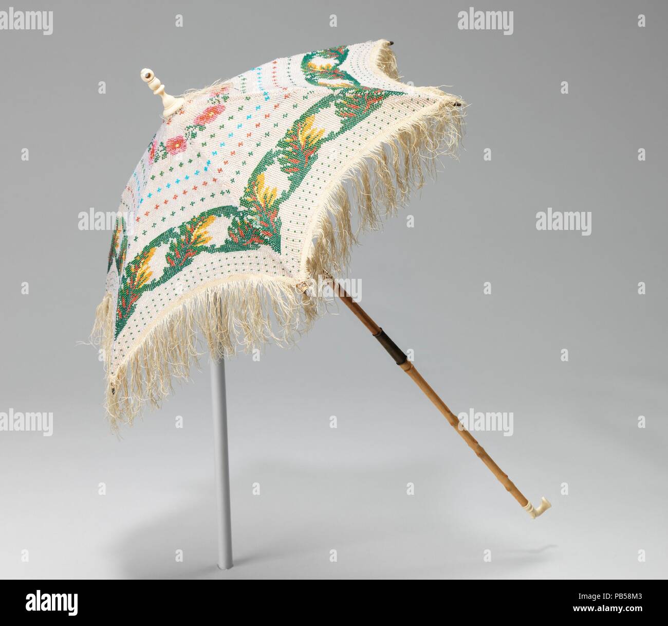 Parasol. Culture : L'Américain. Date : ca. 1870. Ce parasol aurait été  l'ultime vanité de la mode parce qu'il n'est ni protection ni  fonctionnelle. C'est le plus petit parasol dans le Brooklyn