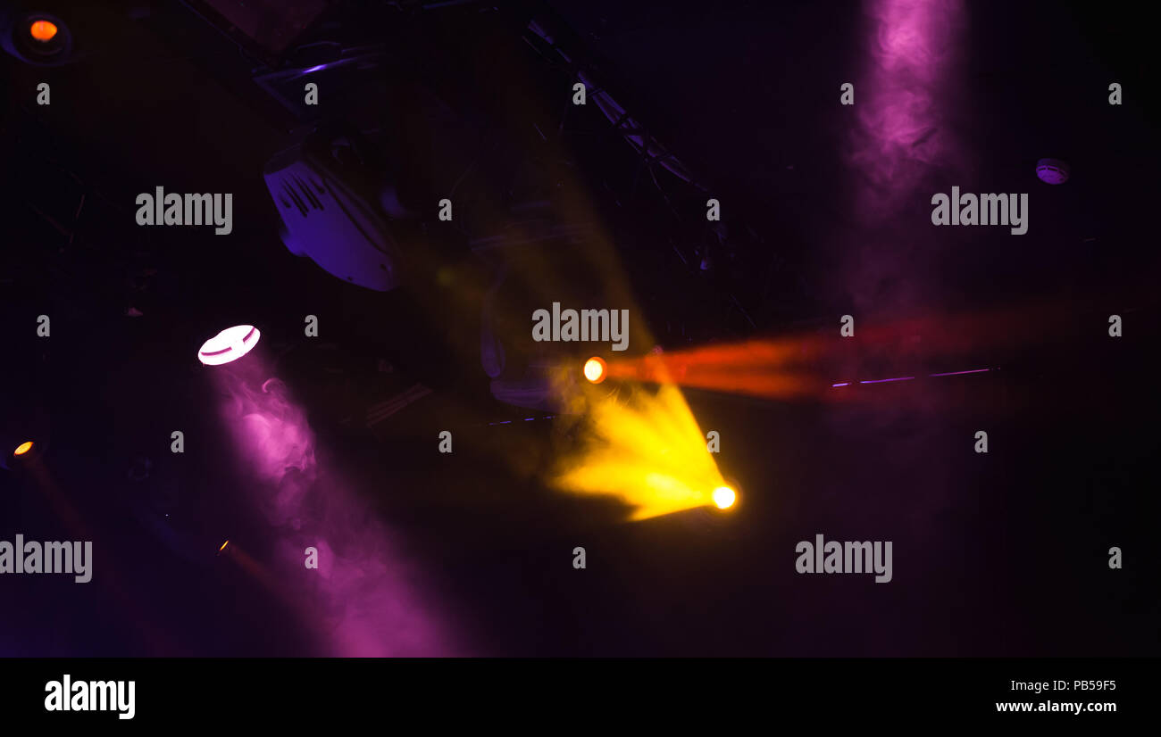 Projecteurs avec des poutres apparentes en fumée sur fond sombre, stade moderne d'équipement d'éclairage Banque D'Images