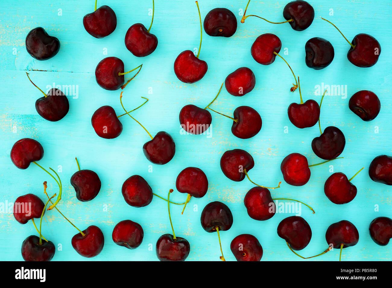 Sweet cerise noire sur fond acqua rustique en bois dans la composition des plats Banque D'Images