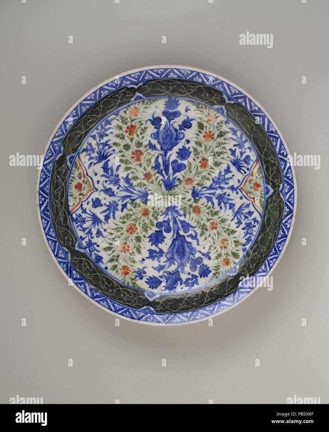 Lave de motifs floraux. Dimensions : H. 2 1/2 in. (6,4 cm) Diam. 14 1/4 in. (36,2 cm). Date : 1670. Ce plat fait partie d'un groupe de céramiques polychromes qui ont été produits en Kirman, Iran. La fortune de cette ville dans le sud-est de l'Iran est passé sous Shah 'Abbas I (r.1587-1629) lorsqu'un certain nombre de monuments majeurs ont été commandées. Pour décorer les nouveaux bâtiments et de répondre aux besoins de nouveaux mécènes, de nombreux artisans potiers qualifiés, y compris, s'installe à Kirman. Au cours du xviie siècle un nouveau style de la céramique Kirman a surgi sur la base de motifs chinois. Le plat et de forme, cependant, ont été distinctl Banque D'Images