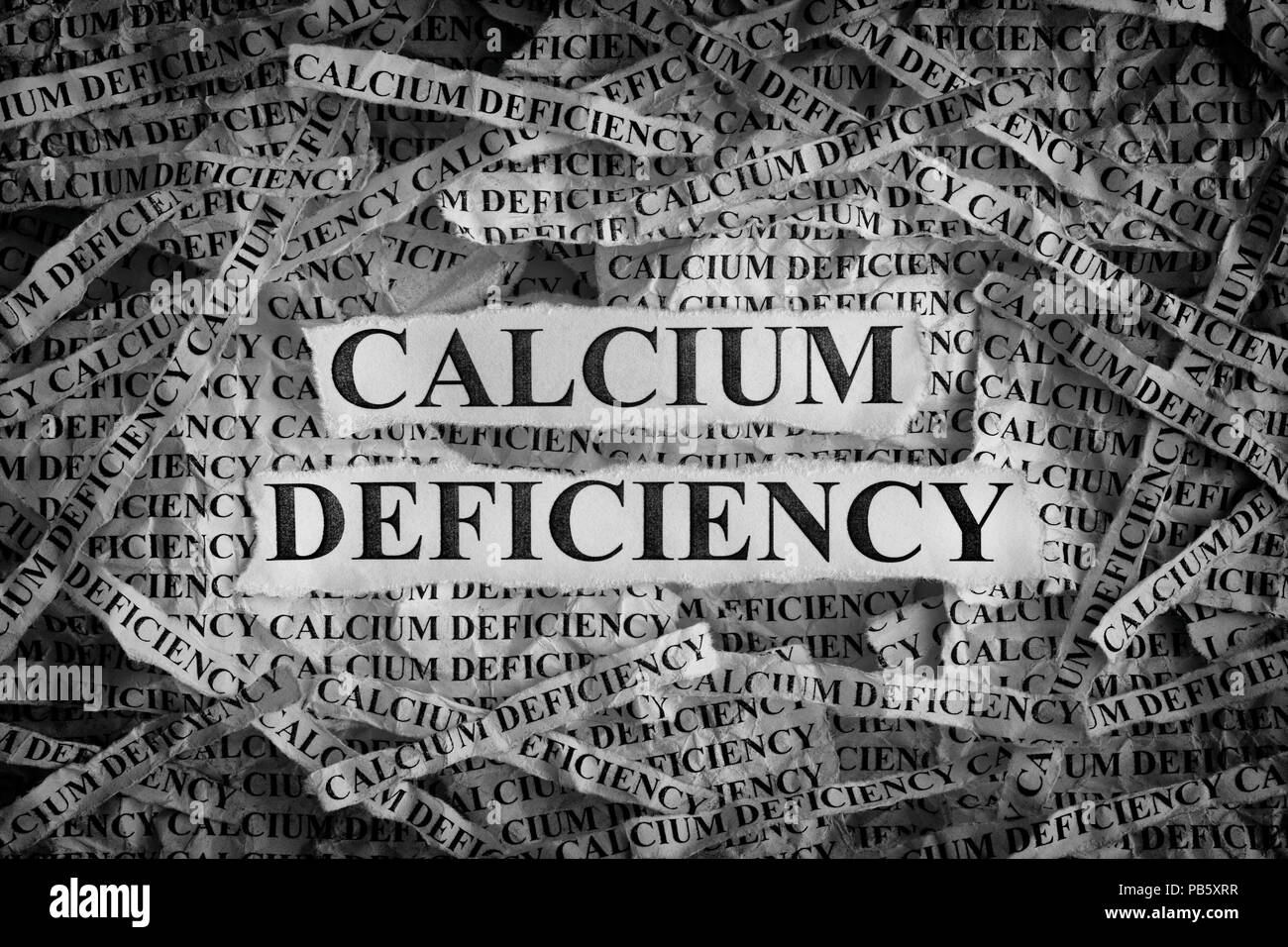 Une carence en calcium. Morceaux de papier avec les mots une carence en calcium. Notion de droit. Noir et blanc. Libre. Banque D'Images