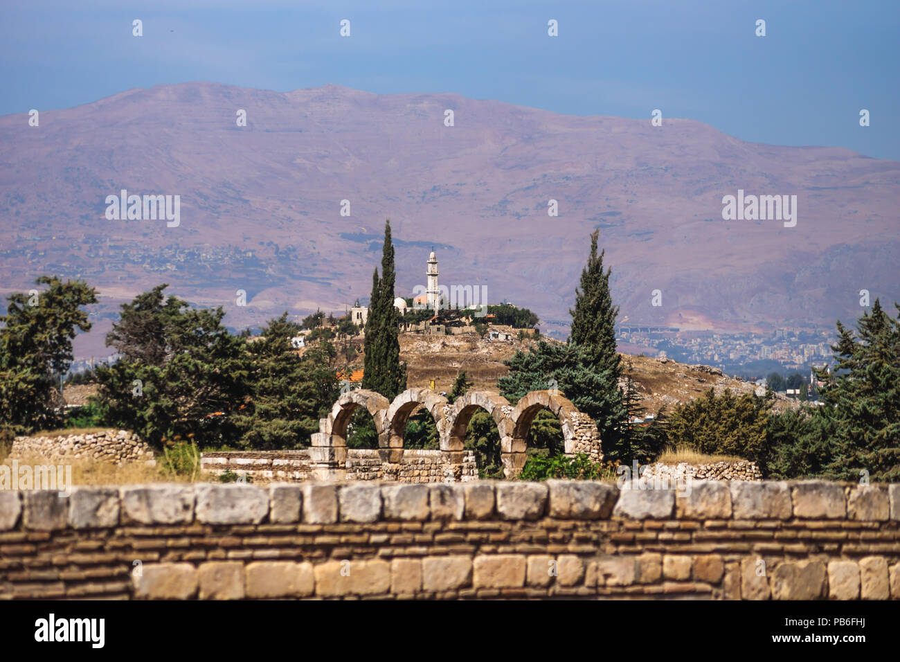 Mosquée sur une colline avec des montagnes en arrière-plan sur une journée ensoleillée et ciel bleu à Anjar, vallée de la Bekaa, au Liban Banque D'Images