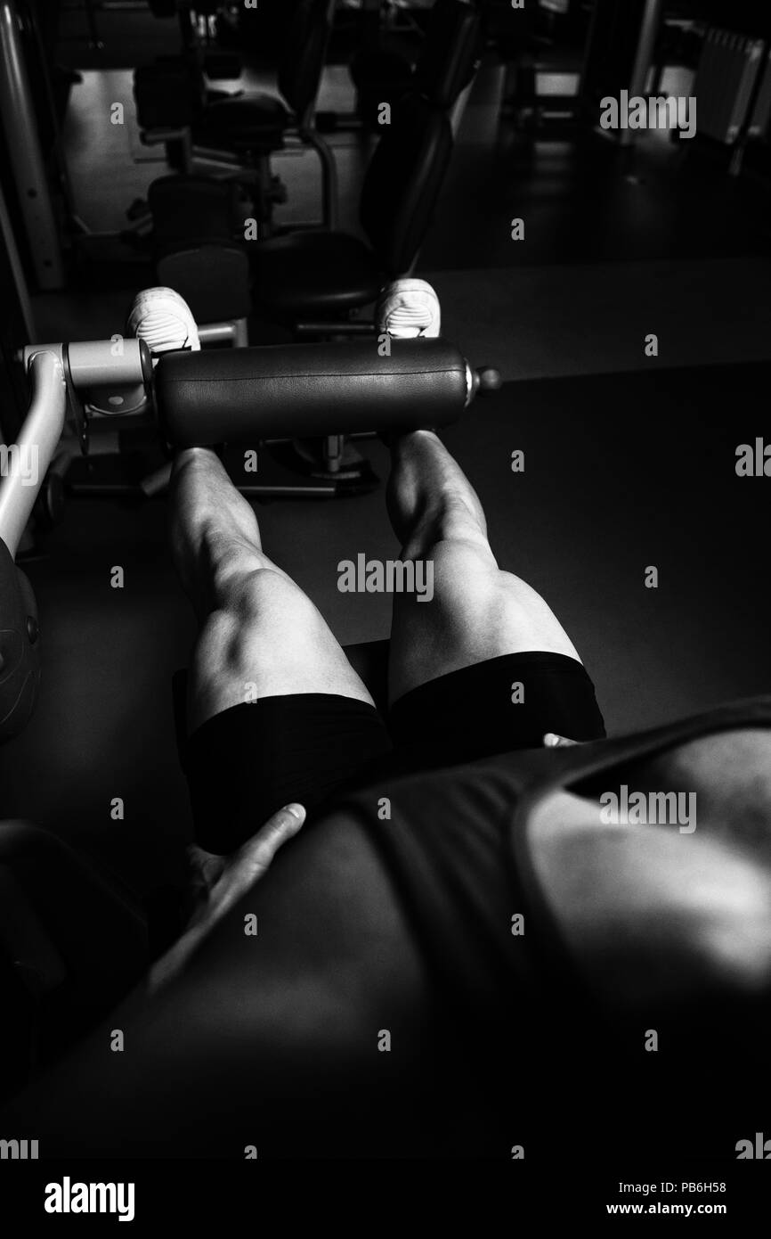 Les jambes Close Up - Homme faisant la jambe avec la machine dans une salle de sport Banque D'Images