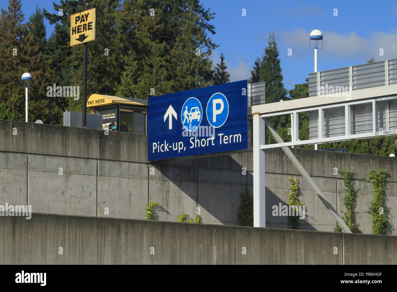 Court terme bleu Parking Sign avec des arbres et de béton à l'arrière-plan Banque D'Images